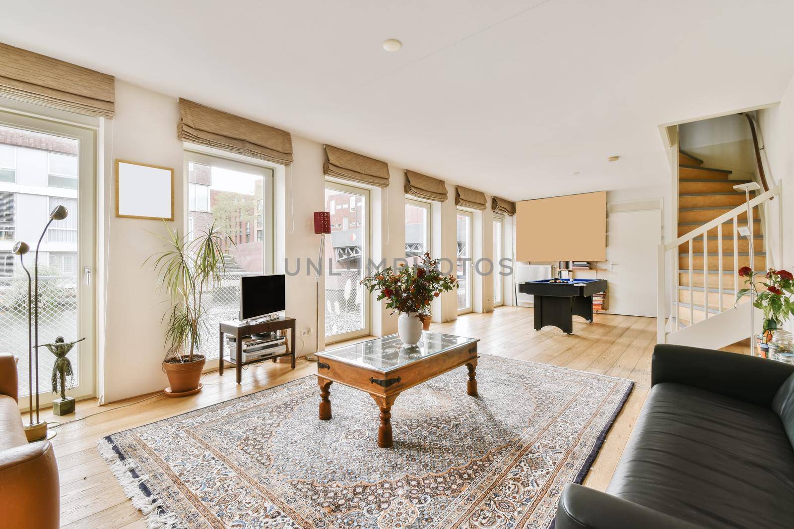 Lovely living room with black leather sofa and wooden coffee table