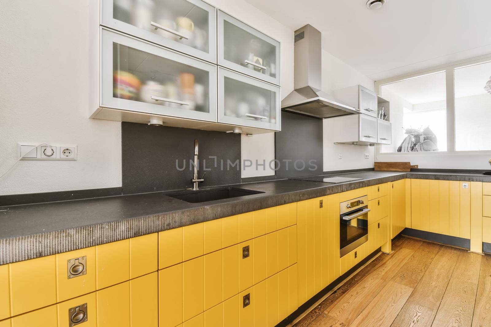 Pretty kitchen with yellow kitchen unit and hanging cabinets with frosted glass