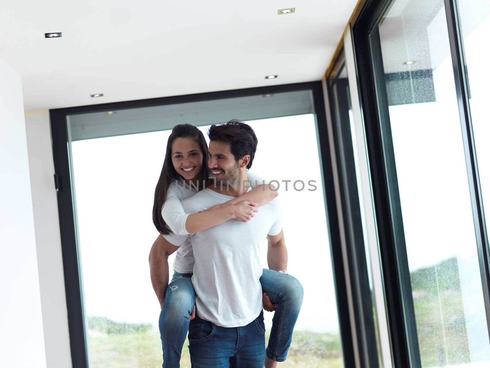 happy young romantic couple have fun relax smile at modern home livingroom indoors