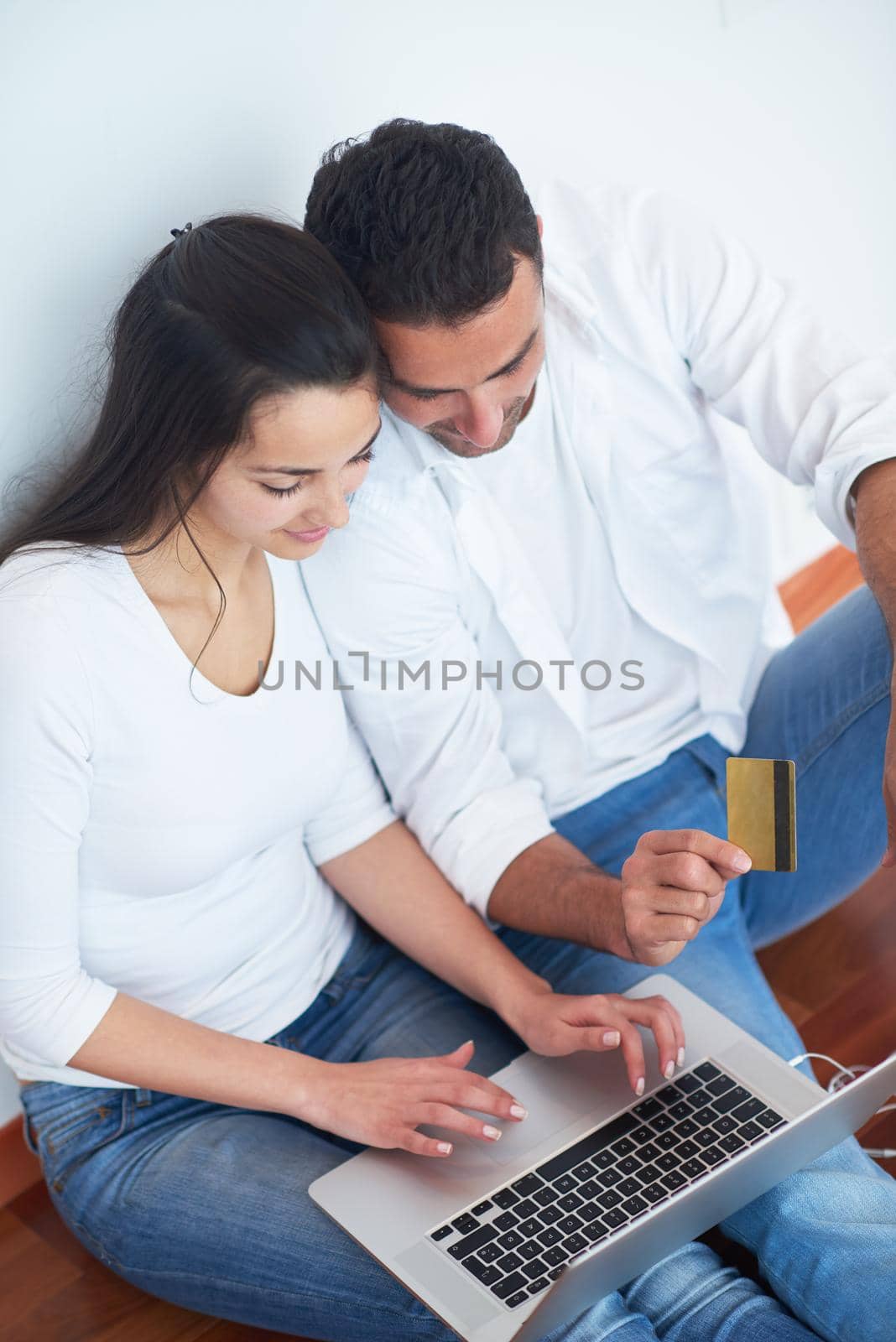 happy young relaxed  couple working on laptop computer at modern home interior