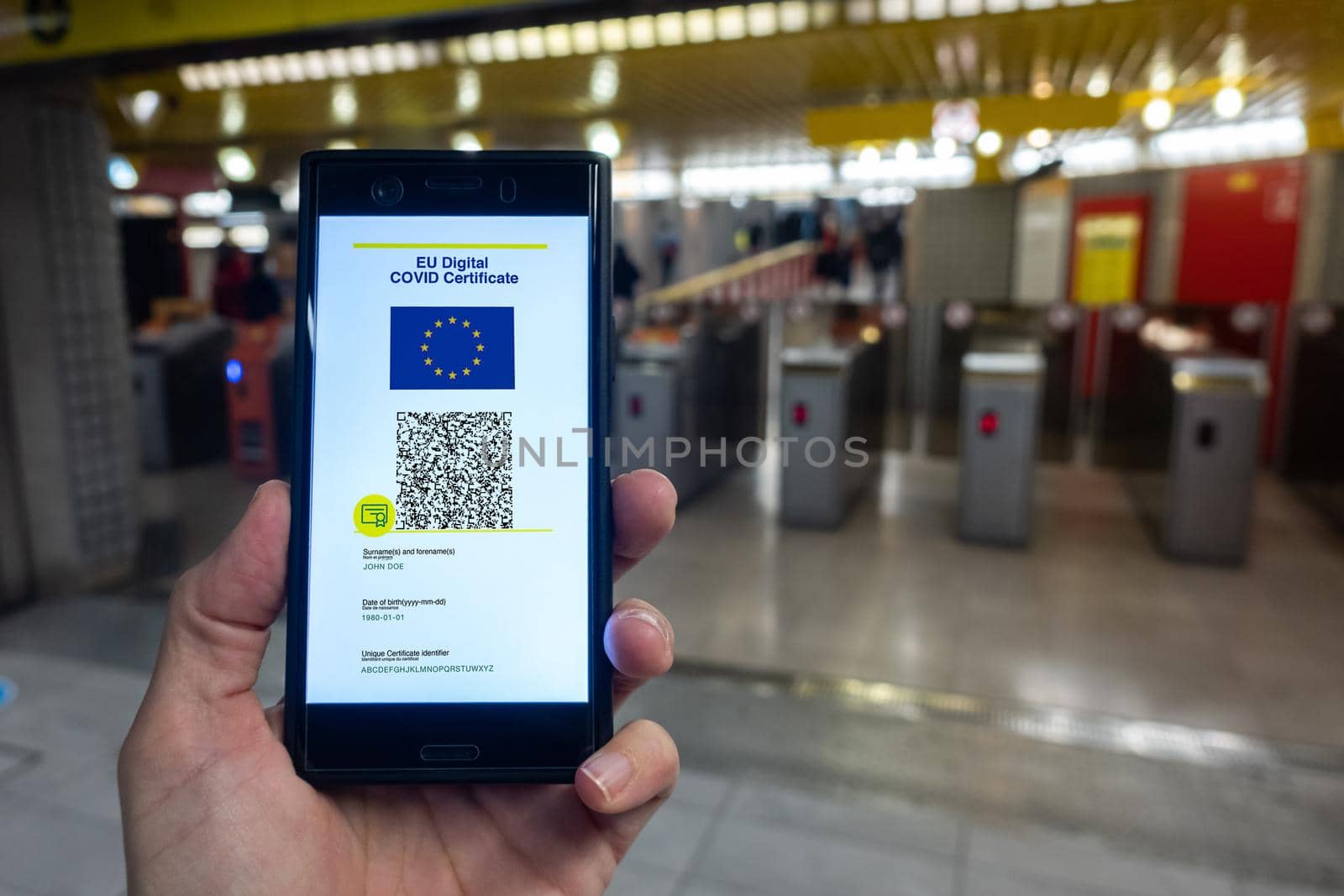 Woman showing EU Digital Covid Certificate on smartphone. Underground background.