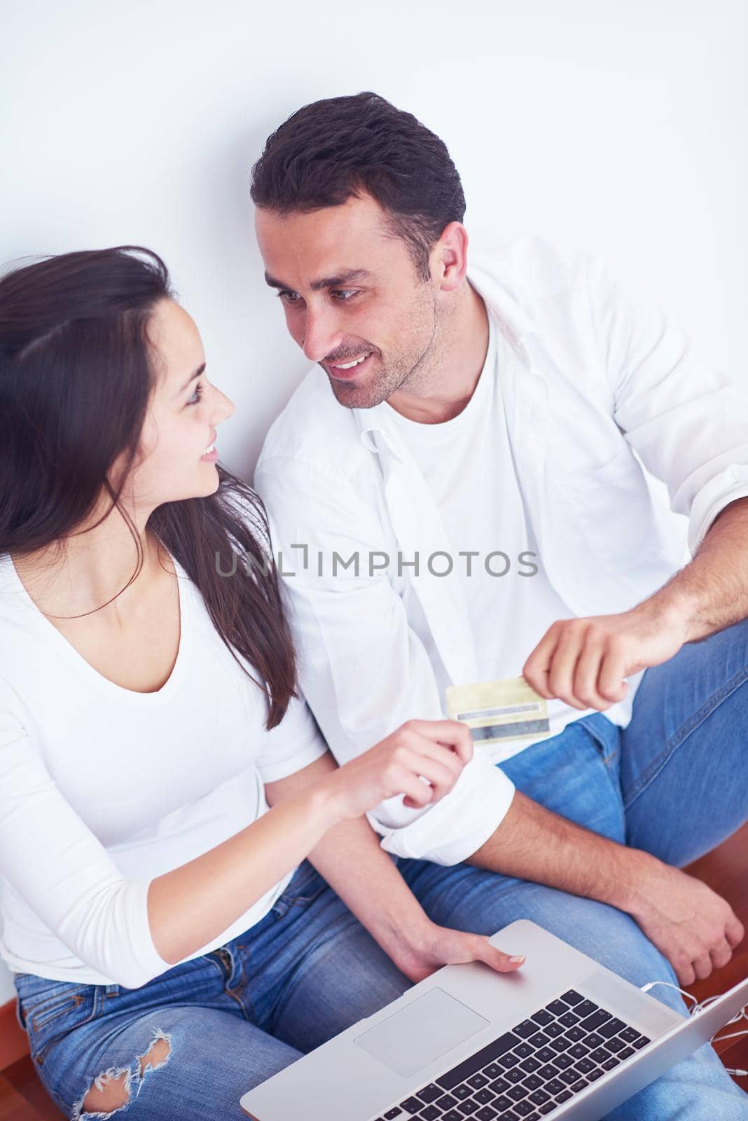 happy young relaxed  couple working on laptop computer at modern home interior