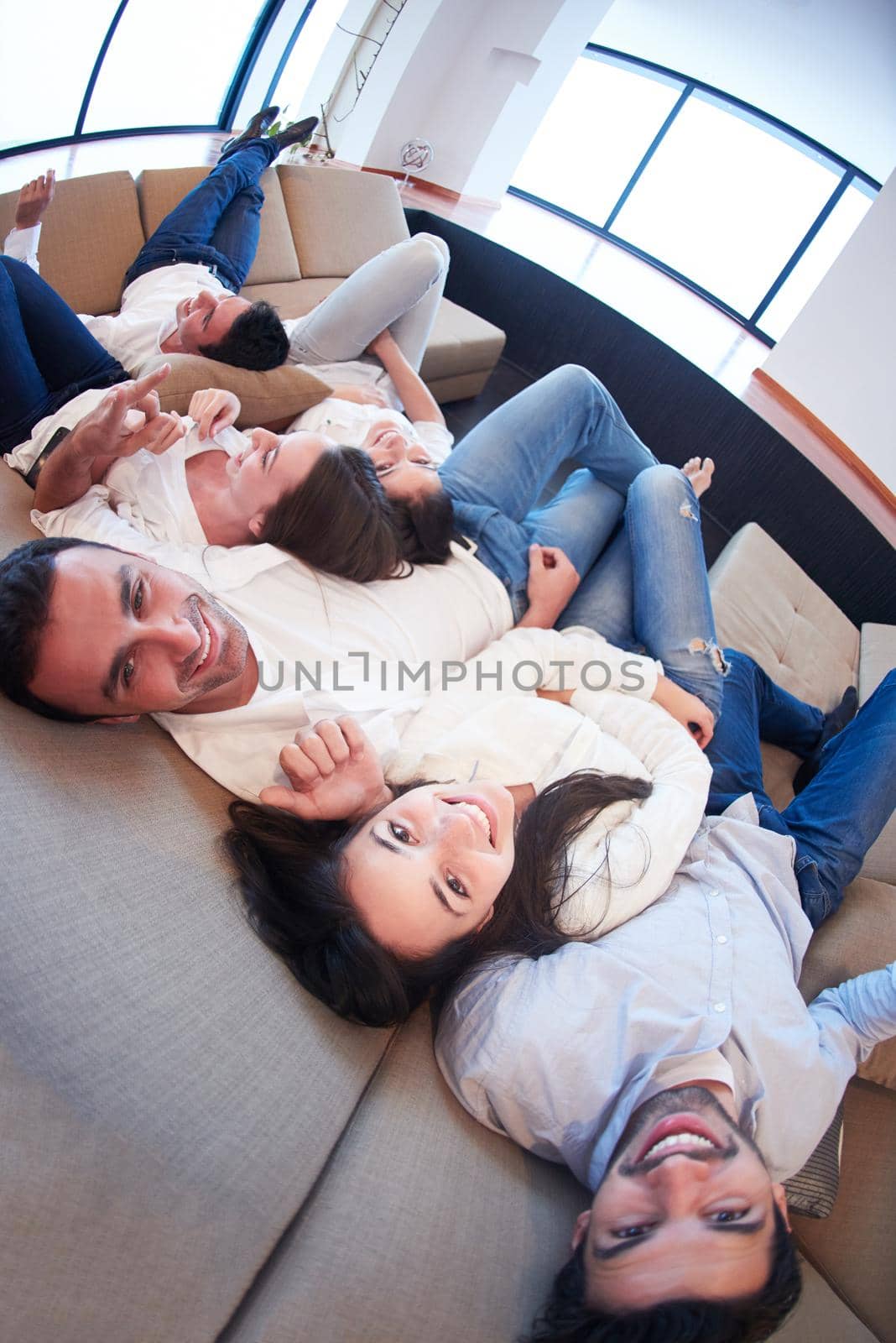 portrait of happy young group of friends get releax and have fun at modern home interior, top view