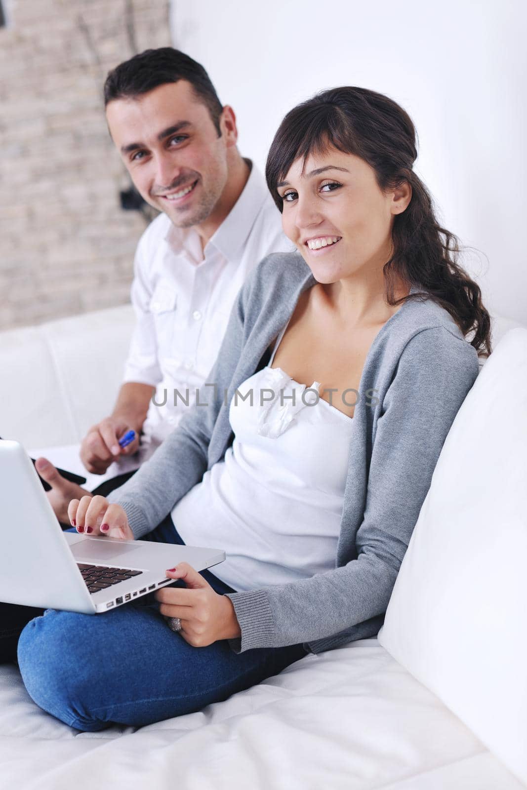 joyful couple relax and work on laptop computer at modern living room indoor home