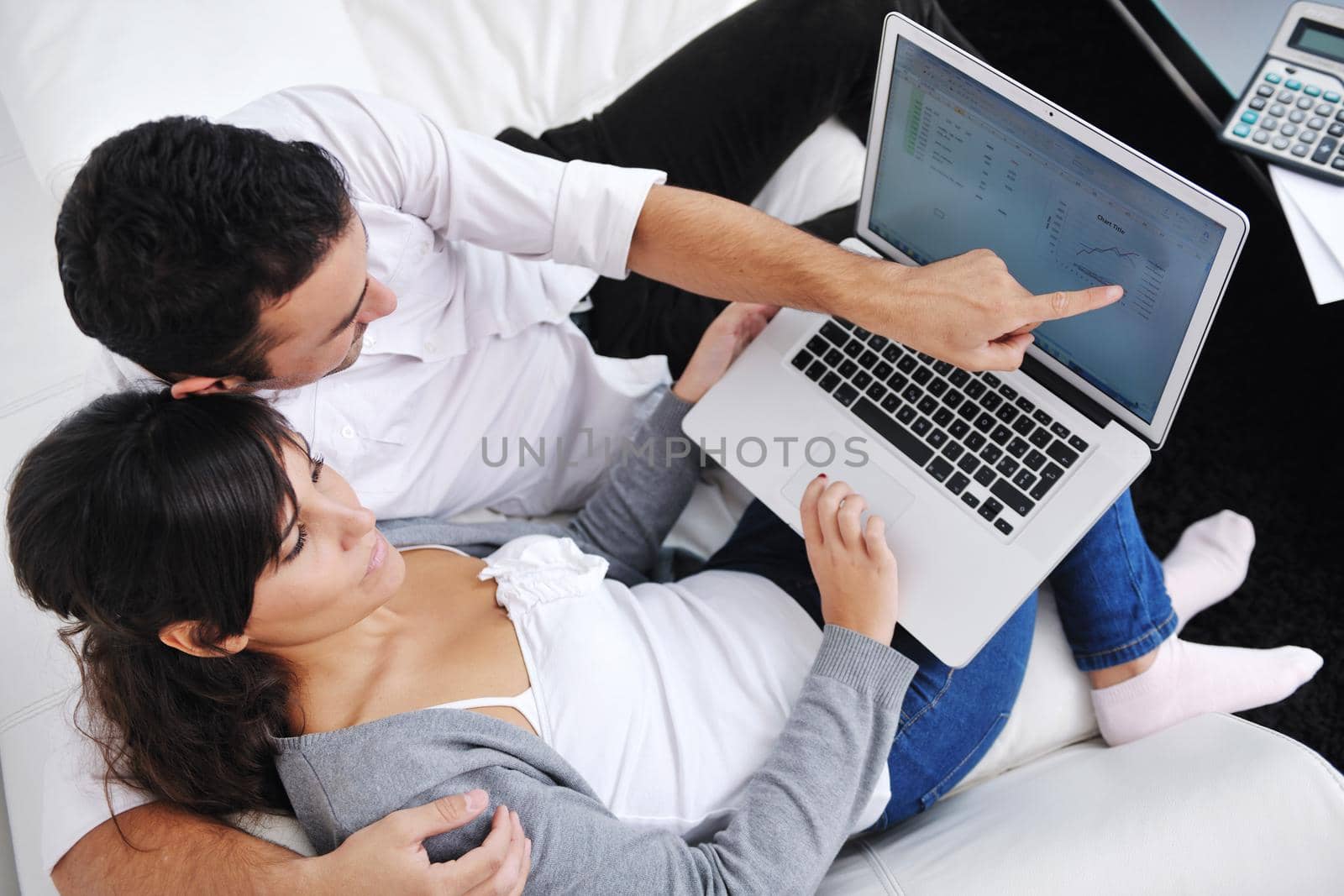 joyful couple relax and work on laptop computer at modern living room indoor home