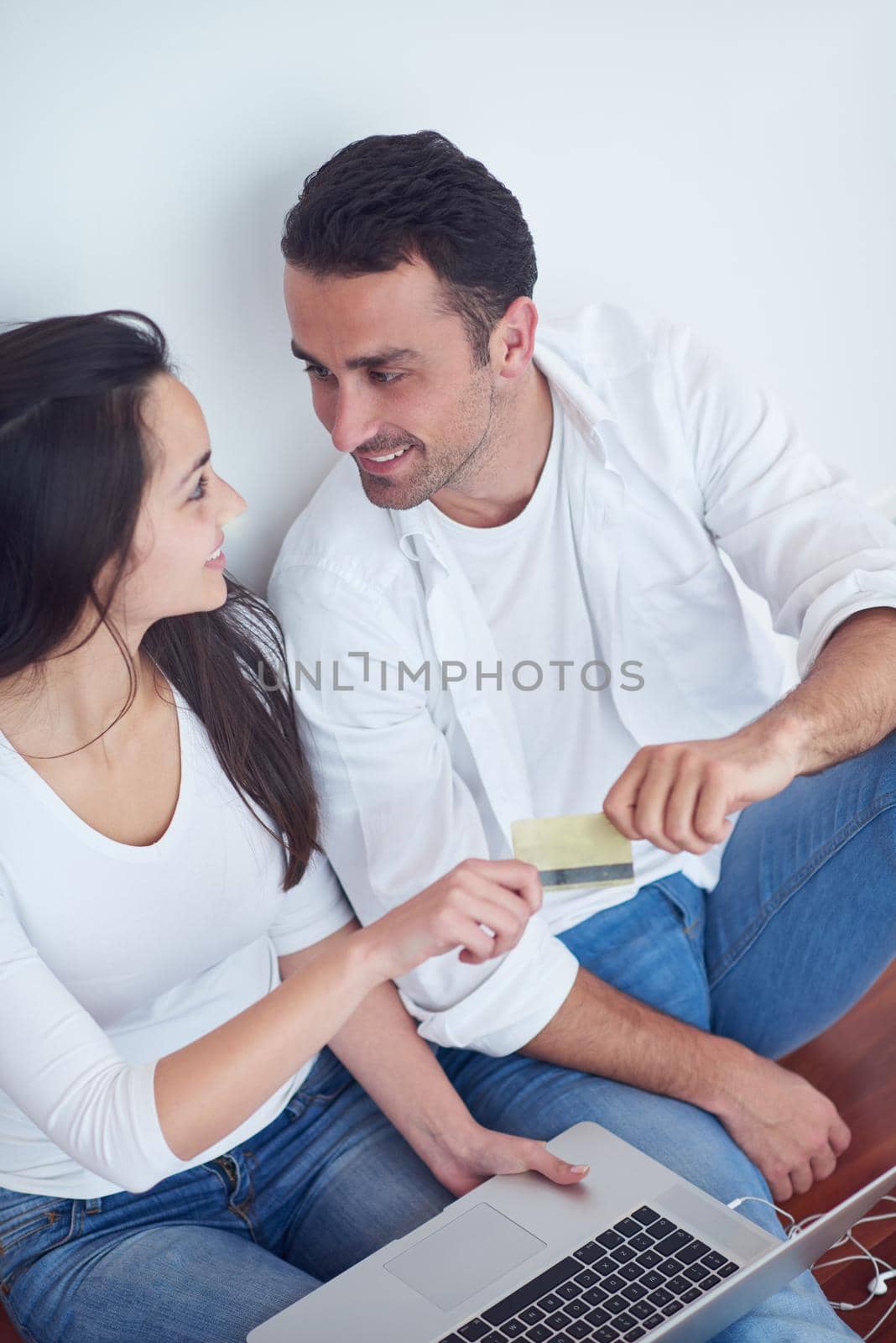 happy young relaxed  couple working on laptop computer at modern home interior