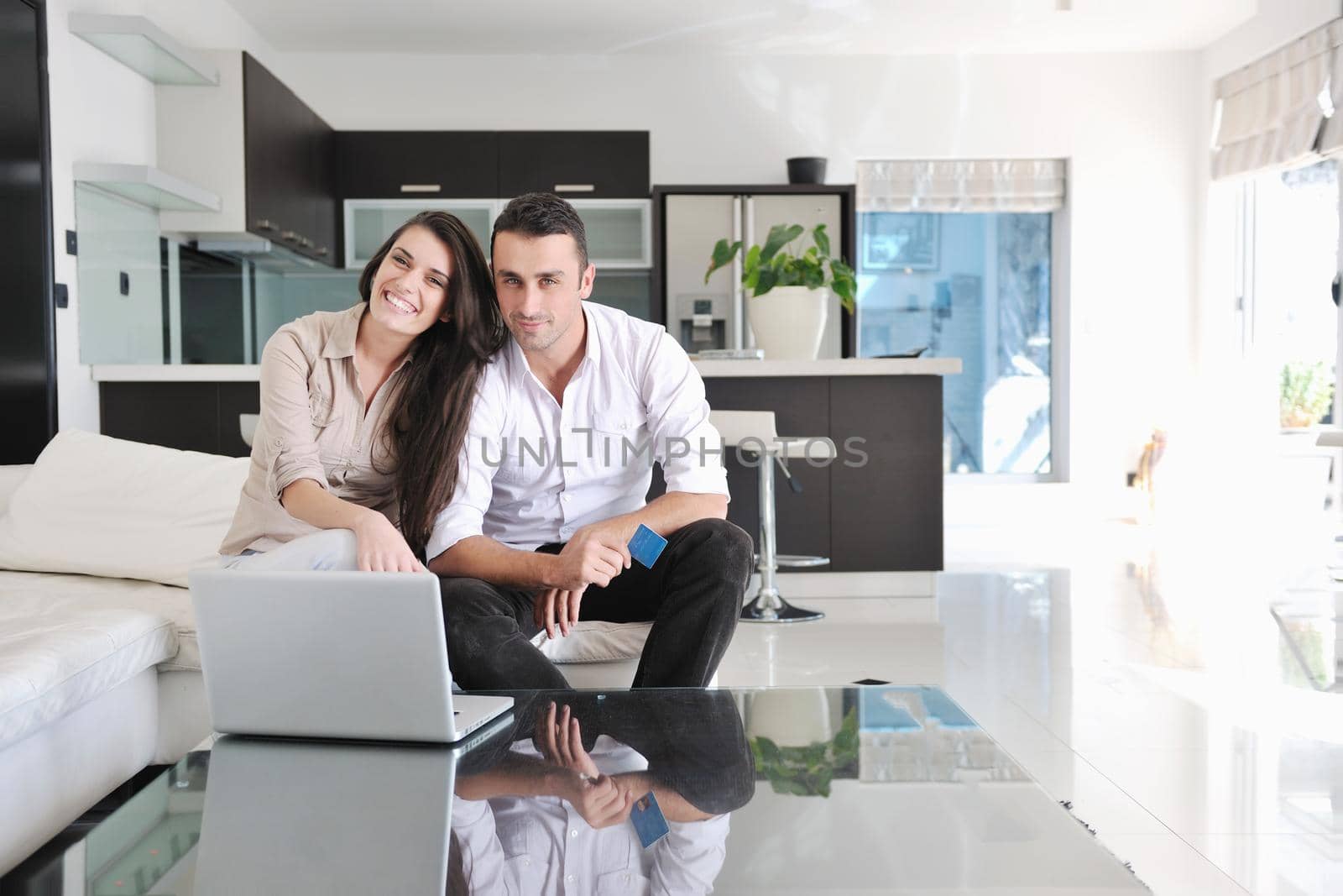 joyful couple relax and work on laptop computer at modern living room indoor home