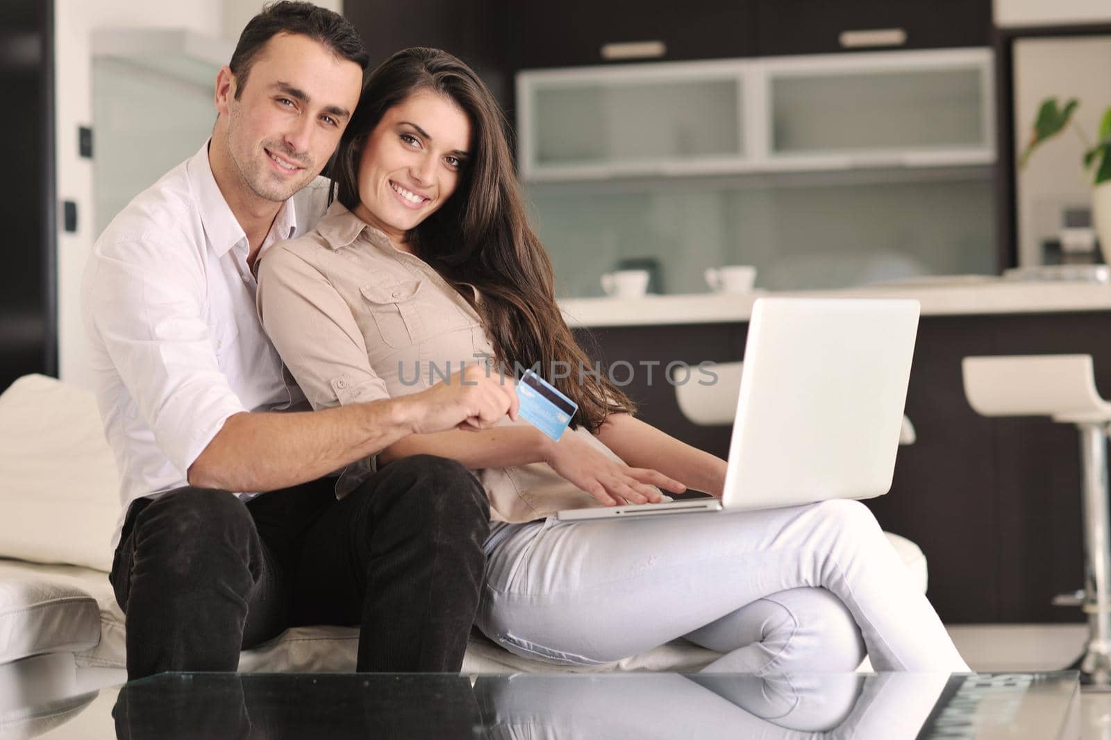 joyful couple relax and work on laptop computer at modern living room indoor home