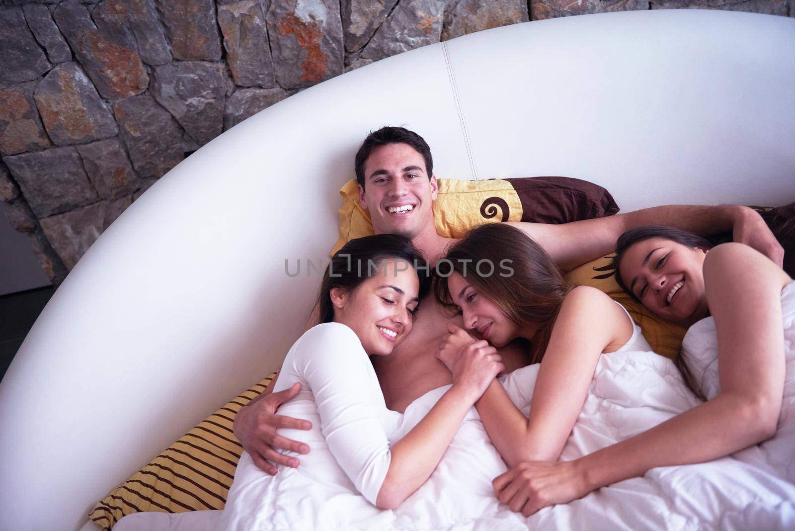 handsome man in bed with three beautiful woman by dotshock