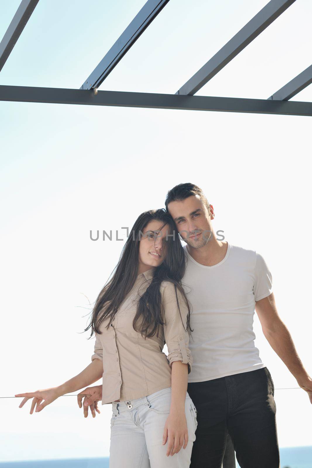 happy young couple in love have romance  relax on balcony outdoor with ocean and blue sky in background