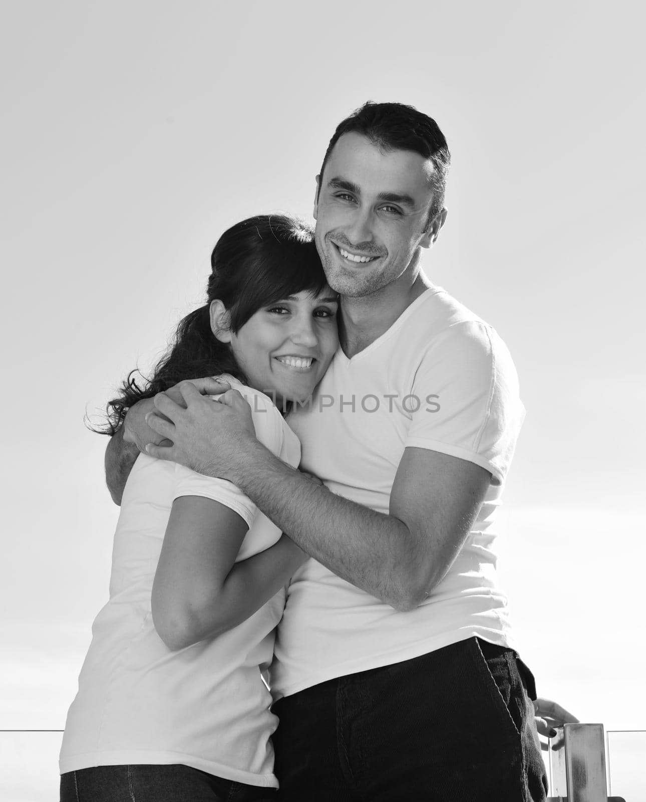 happy young couple relax on balcony outdoor with ocean and blue sky in background