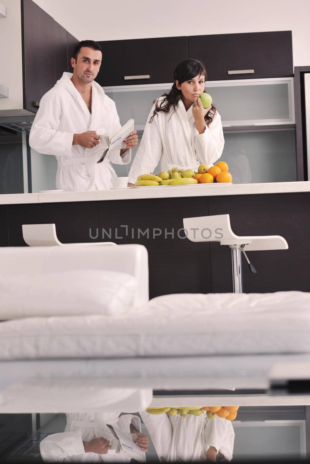 happy young couple have fun in  modern kitchen indoor  while preparing fresh fruits and vegetables food salad