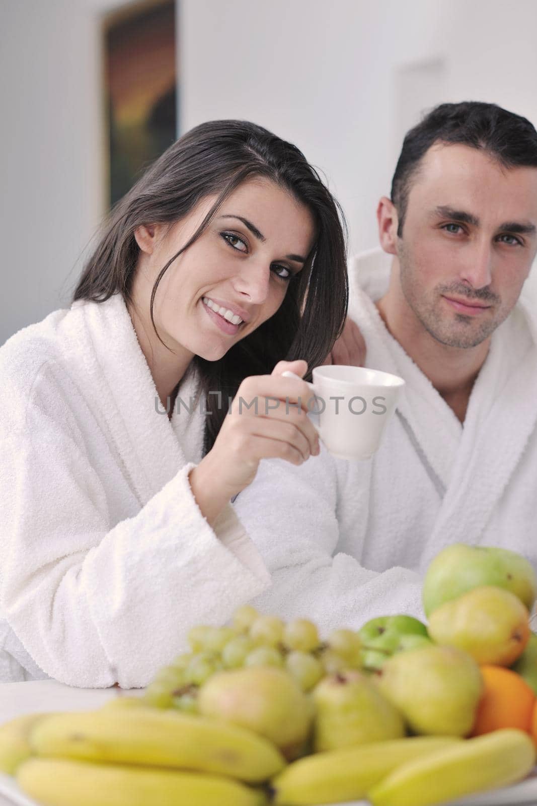 happy young couple have fun in  modern kitchen indoor  while preparing fresh fruits and vegetables food salad