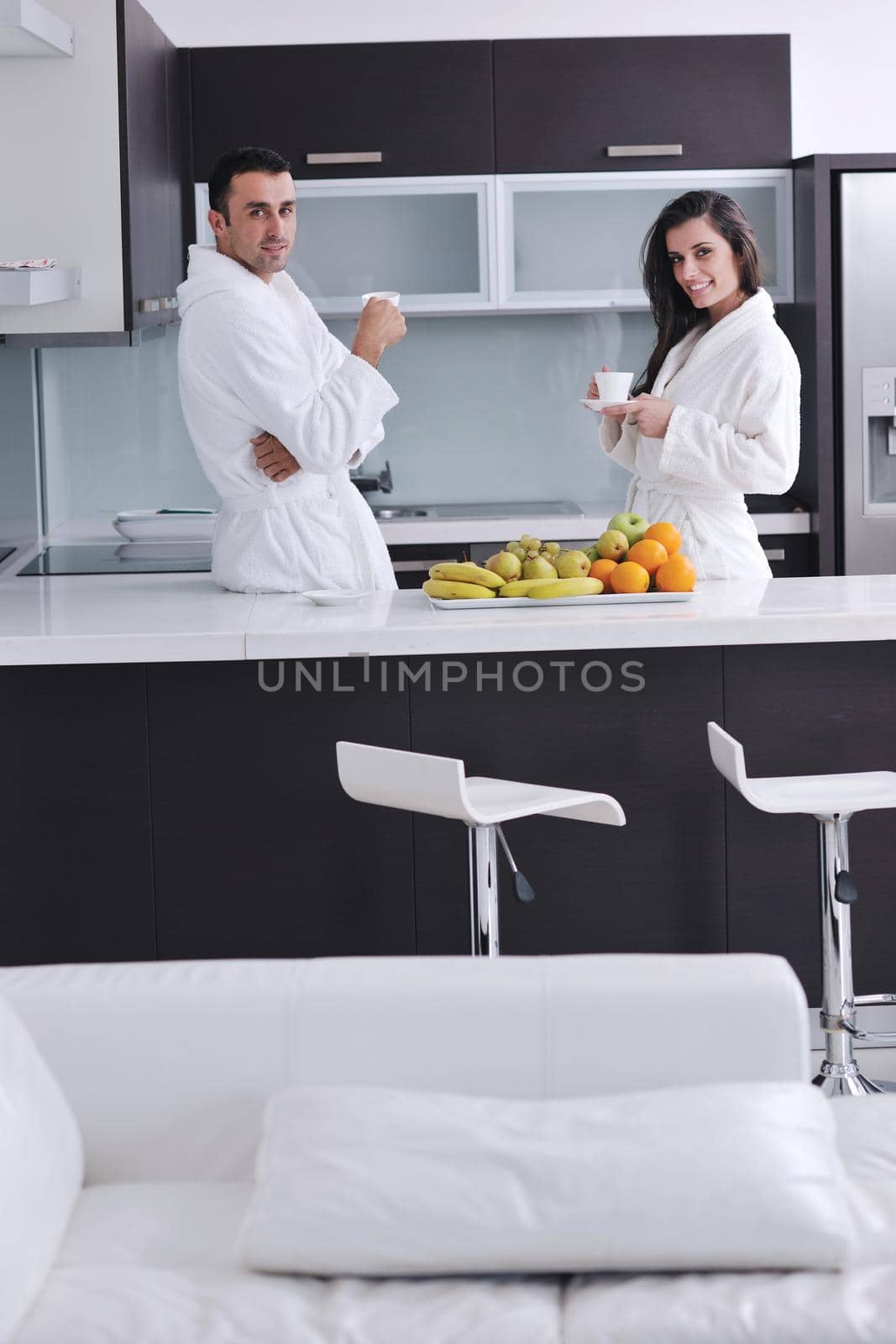 happy young couple have fun in  modern kitchen indoor  while preparing fresh fruits and vegetables food salad