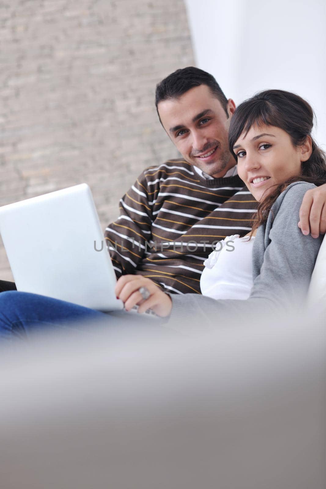 joyful couple relax and work on laptop computer at modern living room indoor home