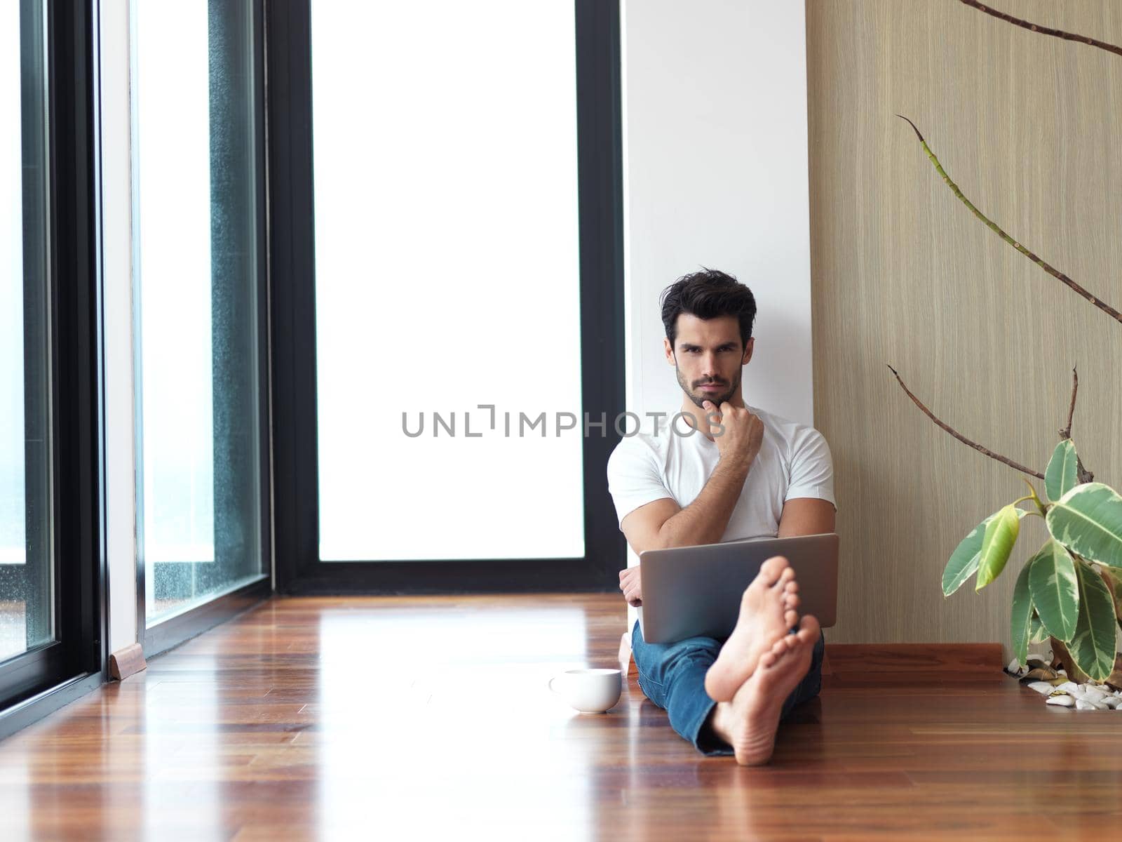 handsome business man in casual clothing working on laptop computer from home and drink firs morning coffee