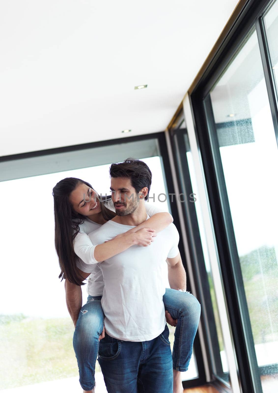 happy young romantic couple have fun relax smile at modern home livingroom indoors