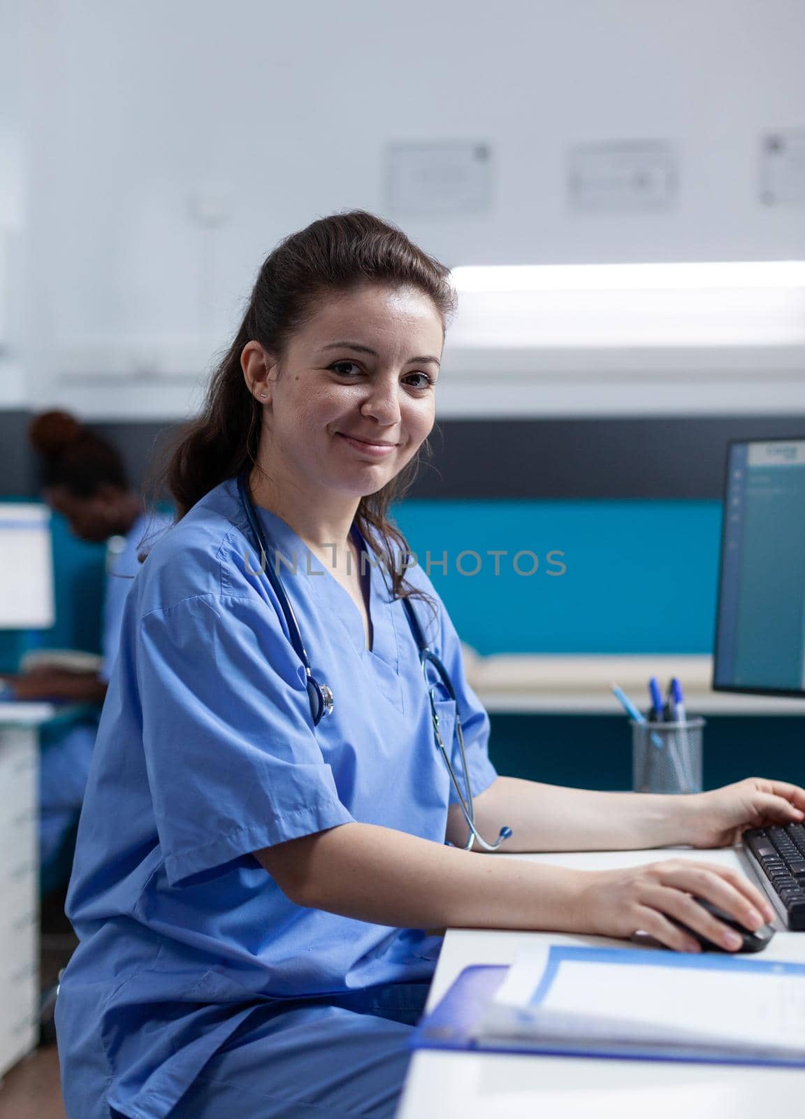 Portrait of pharmacist nurse with medical stethoscope analyzing pharmaceutical prescription during clinical consultation in hospital office. Woman asisstance checking sickness symptoms