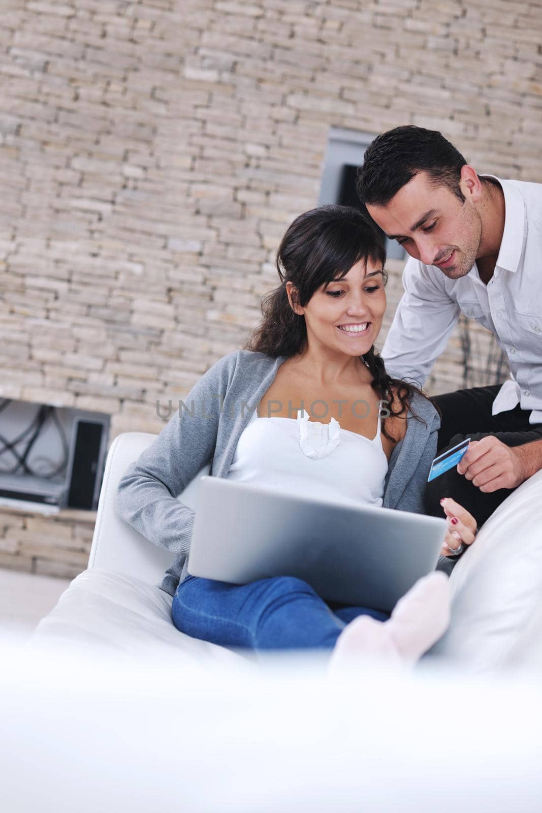 joyful couple relax and work on laptop computer at modern living room indoor home