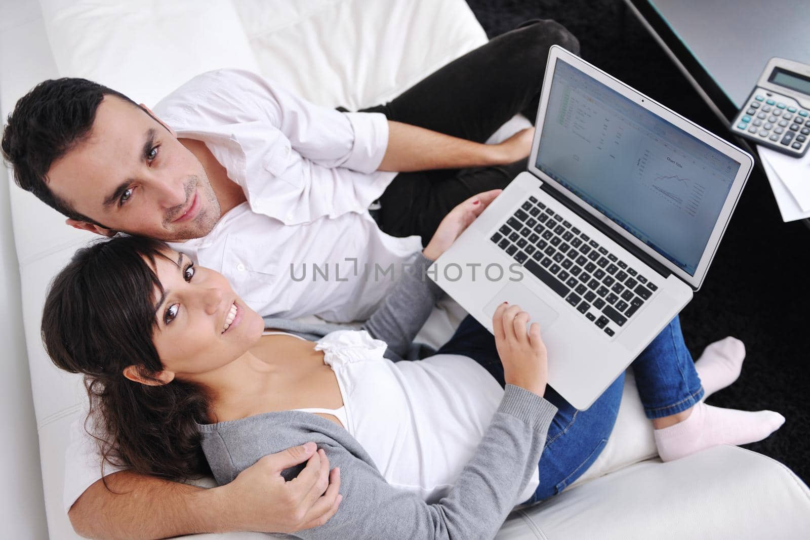 joyful couple relax and work on laptop computer at modern living room indoor home