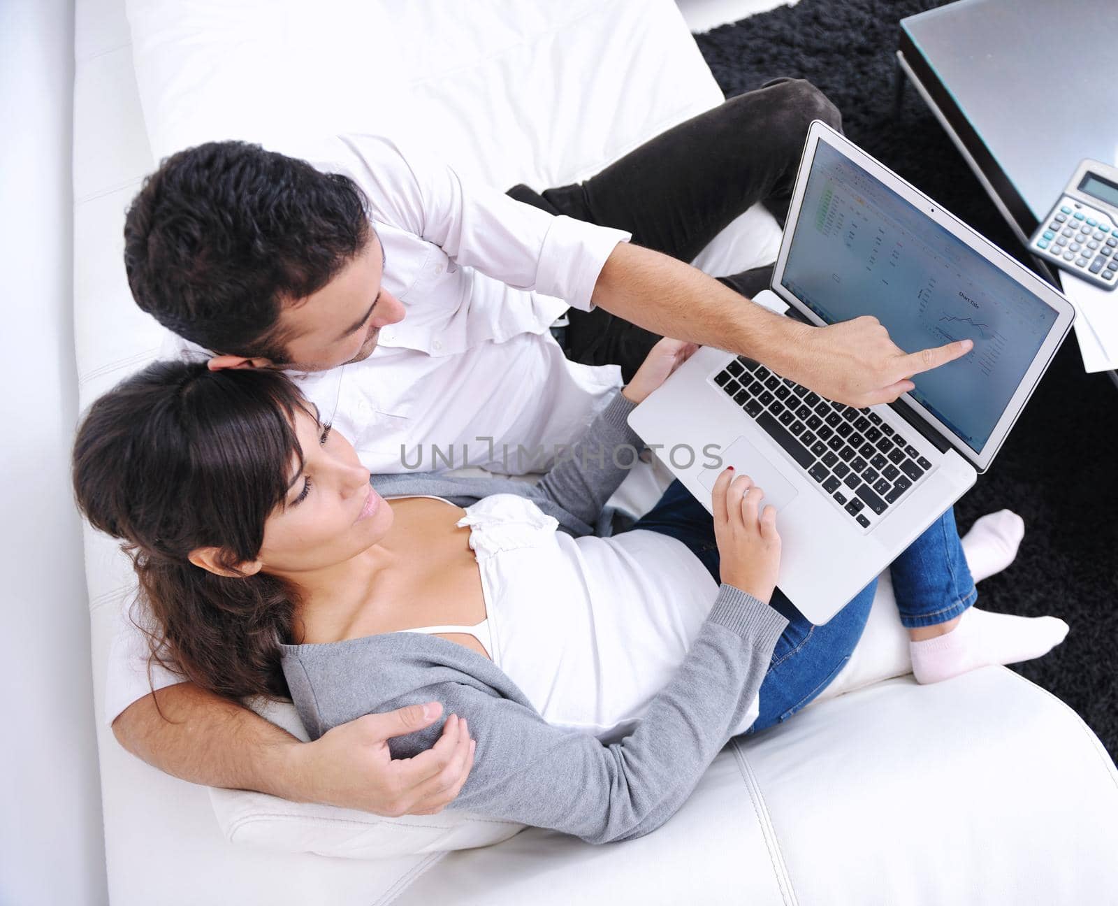 joyful couple relax and work on laptop computer at modern living room indoor home