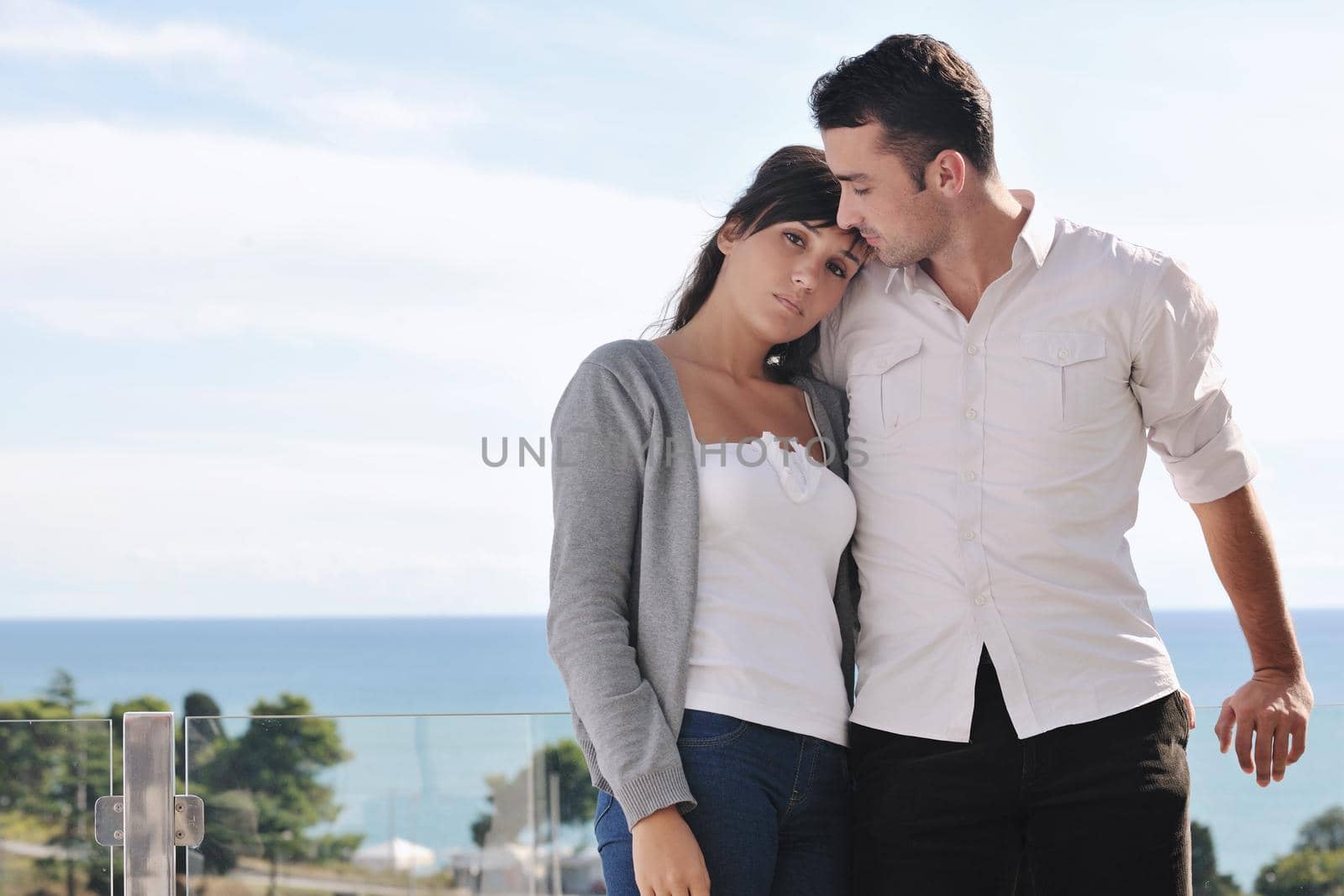 happy young couple in love have romance  relax on balcony outdoor with ocean and blue sky in background