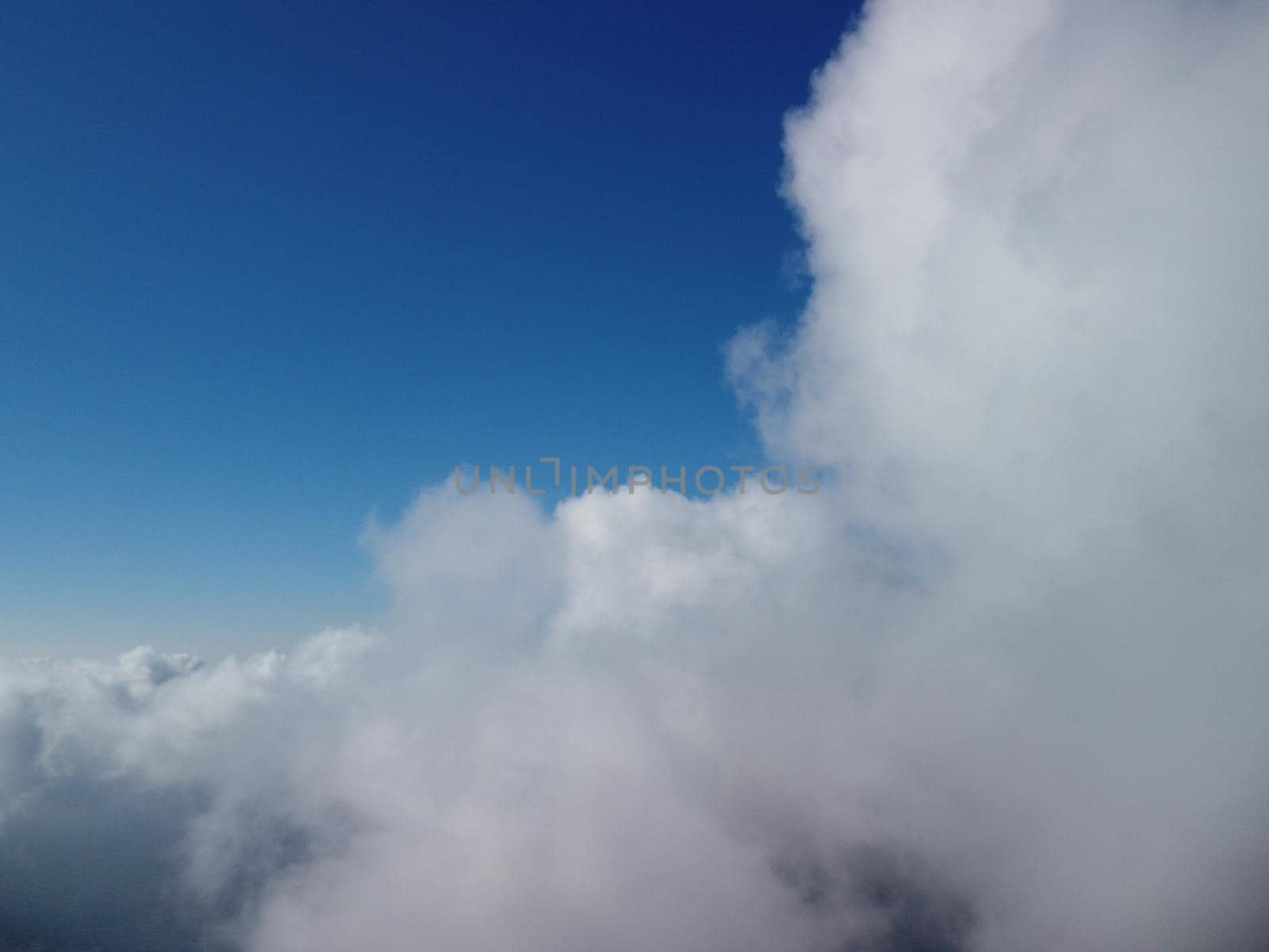 Footage B roll Aerial view drone flying above white clouds dense fog move quickly. Drone flies high back in blue sky through fluffy clouds. Beautiful foggy and cloudy slow moving Aerial view. Fog sea.