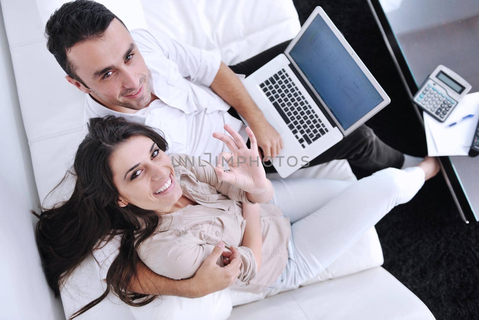 joyful couple relax and work on laptop computer at modern home by dotshock