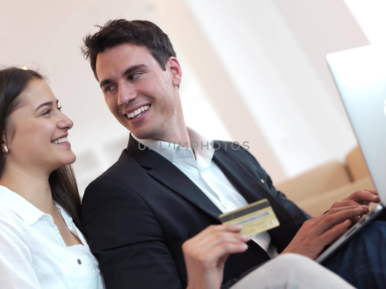 happy young relaxed  couple working on laptop computer at modern home interior