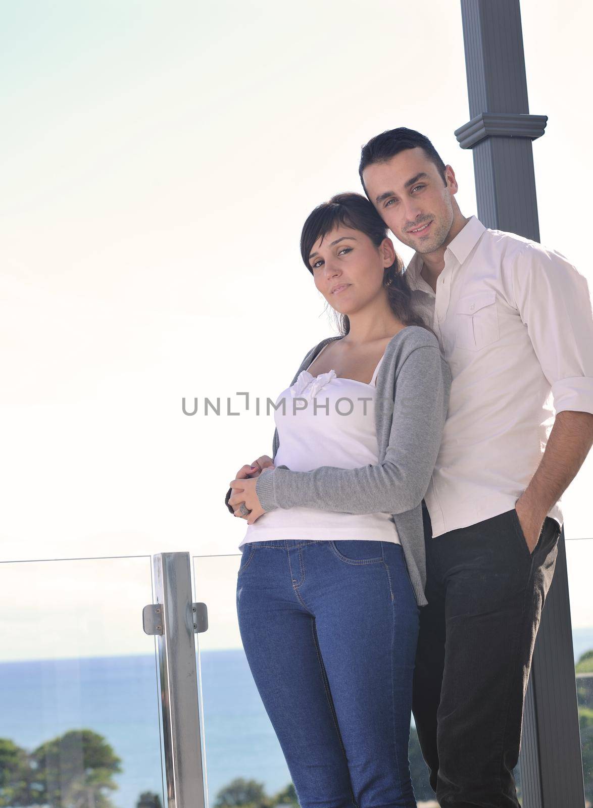 happy young couple in love have romance  relax on balcony outdoor with ocean and blue sky in background