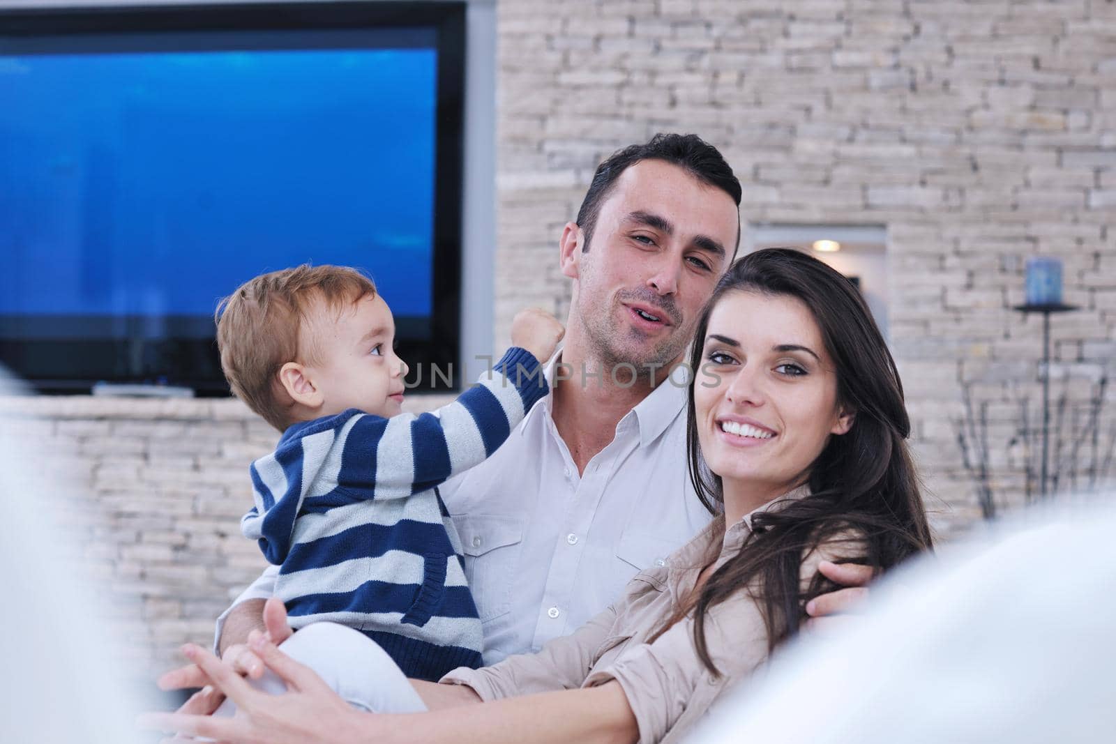 happy young family have fun  with tv in backgrund by dotshock