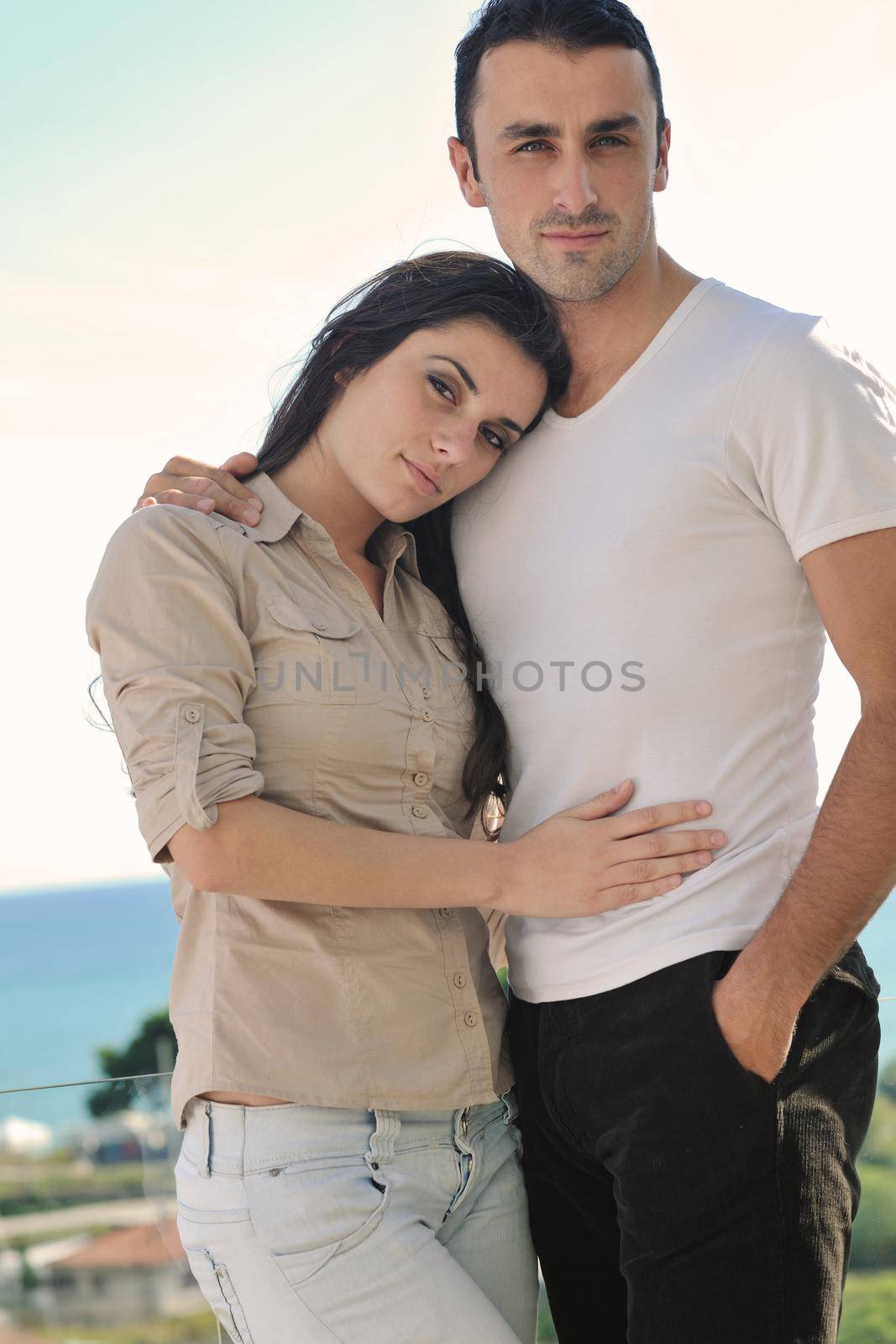 happy young couple in love have romance  relax on balcony outdoor with ocean and blue sky in background