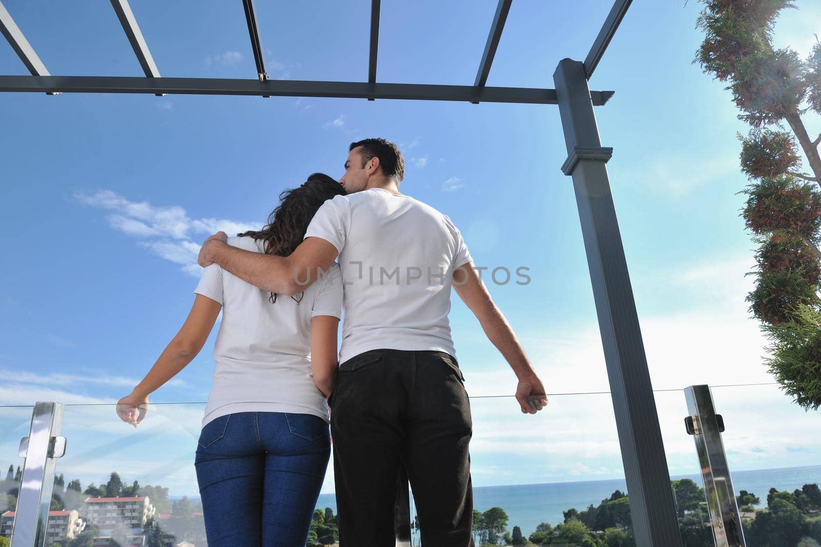 happy young couple relax on balcony outdoor with ocean and blue sky in background