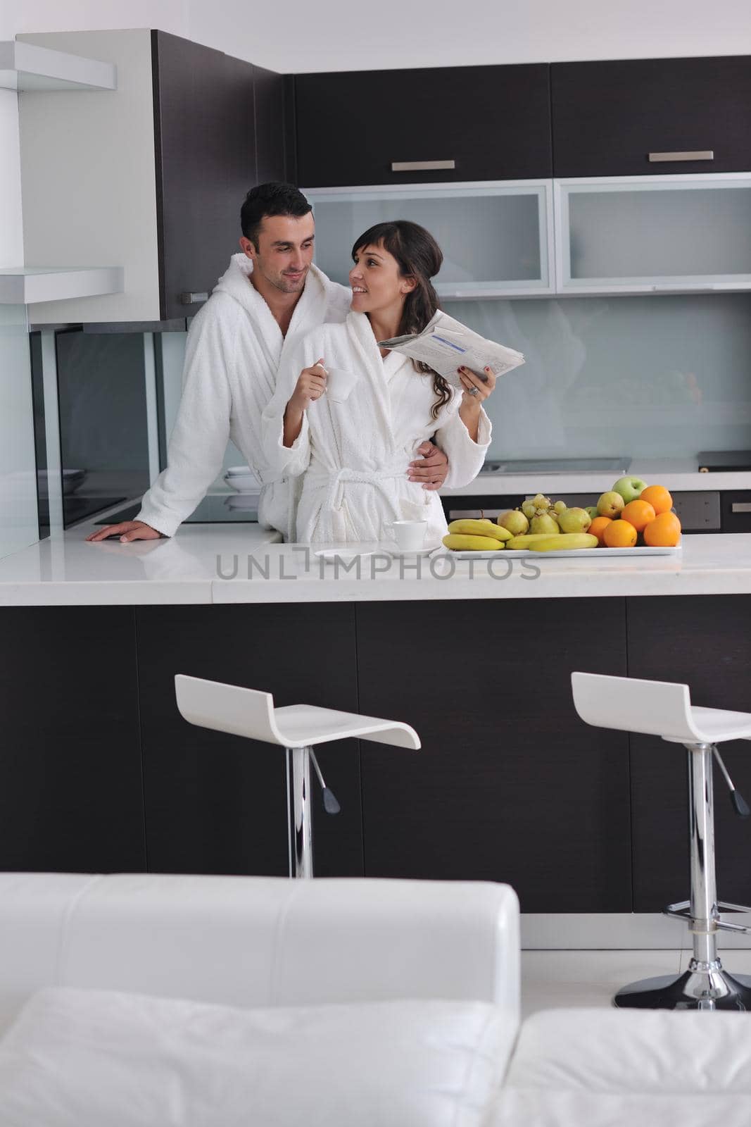 happy young couple have fun in  modern kitchen indoor  while preparing fresh fruits and vegetables food salad