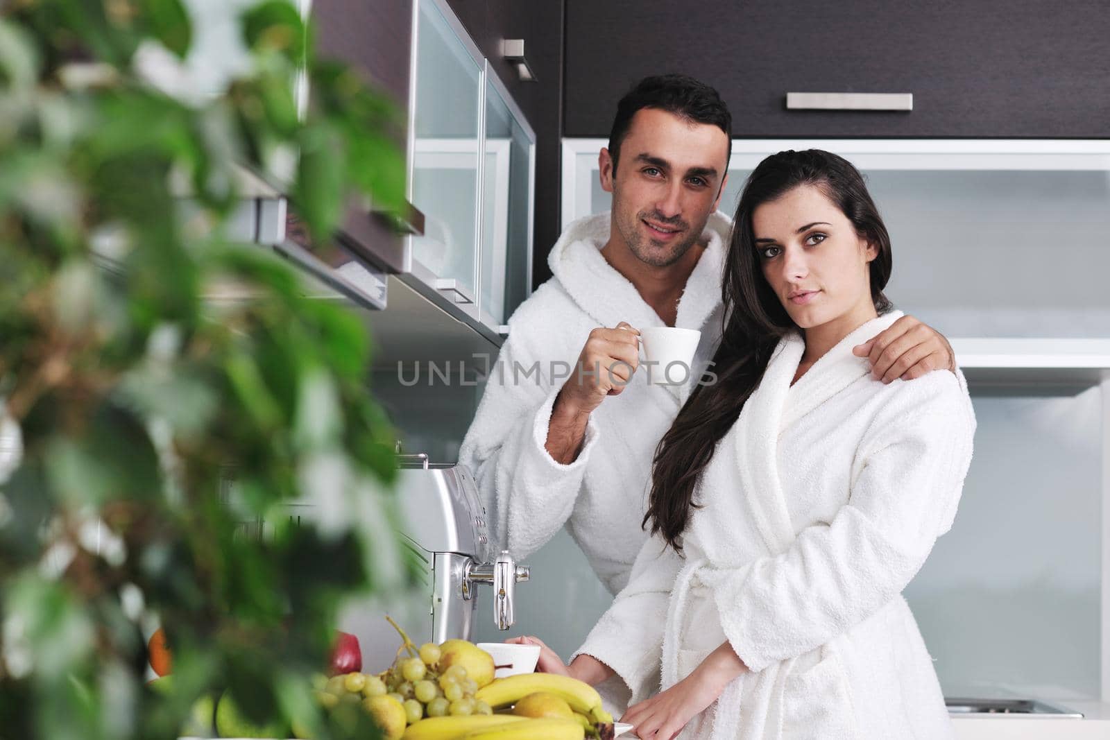 Young love couple taking fresh morning cup of coffee in the modern appartment