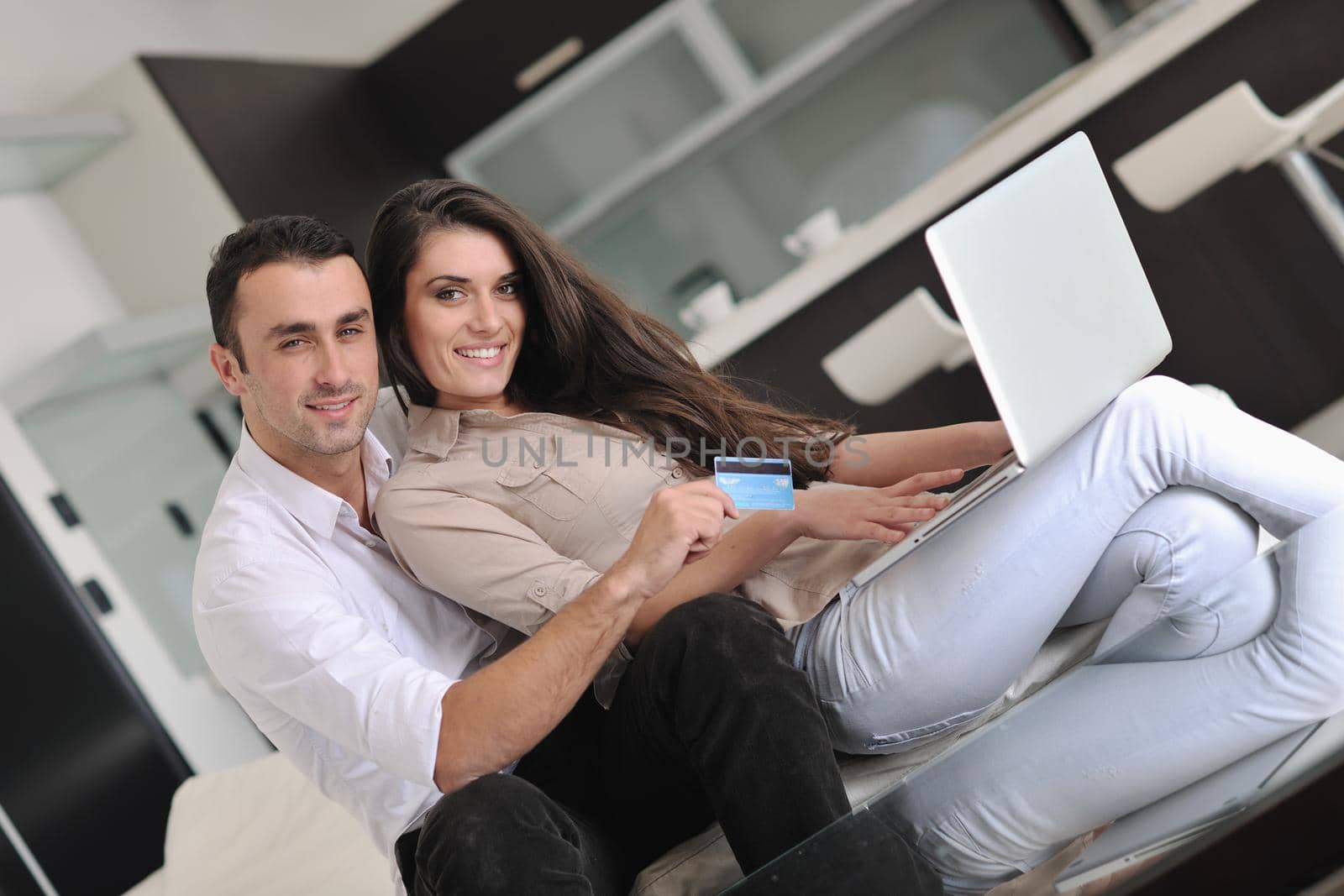 joyful couple relax and work on laptop computer at modern living room indoor home