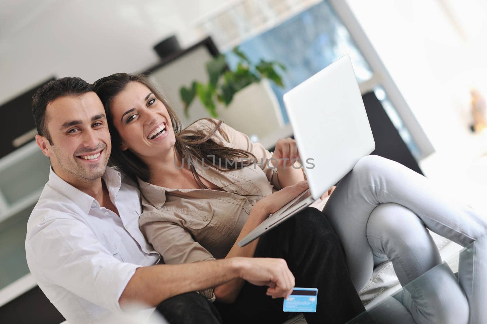 joyful couple relax and work on laptop computer at modern living room indoor home