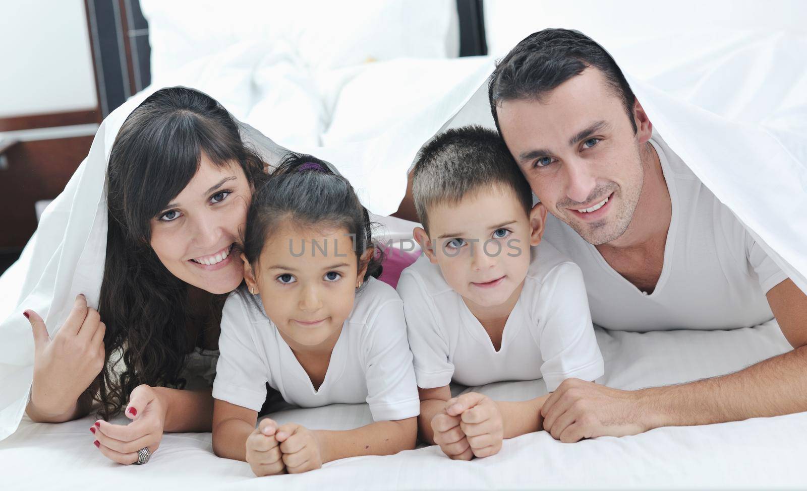 happy young Family in their bedroom have fun and play in bed