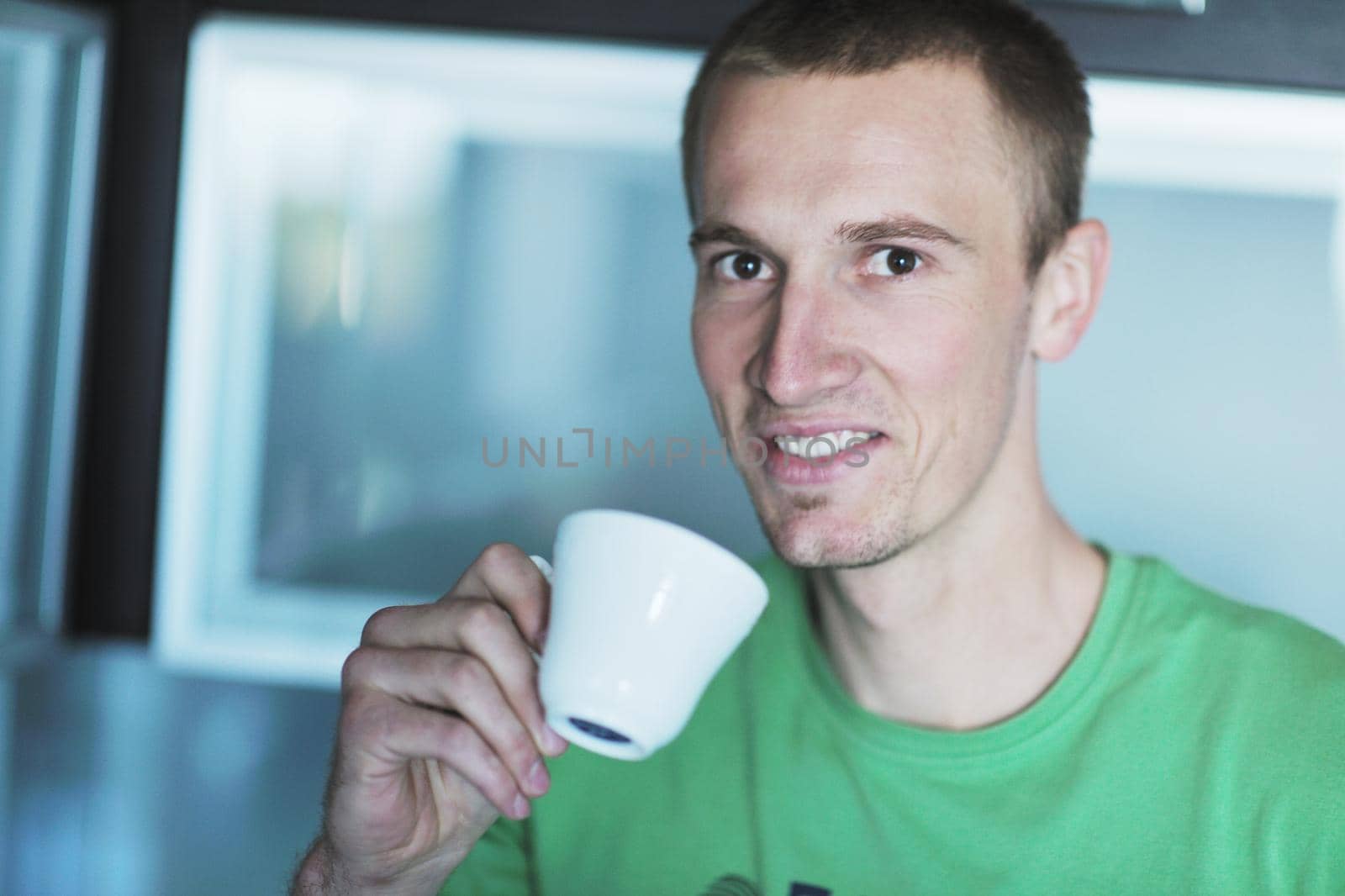 handsome young man drink fresh morning coffee from white cup