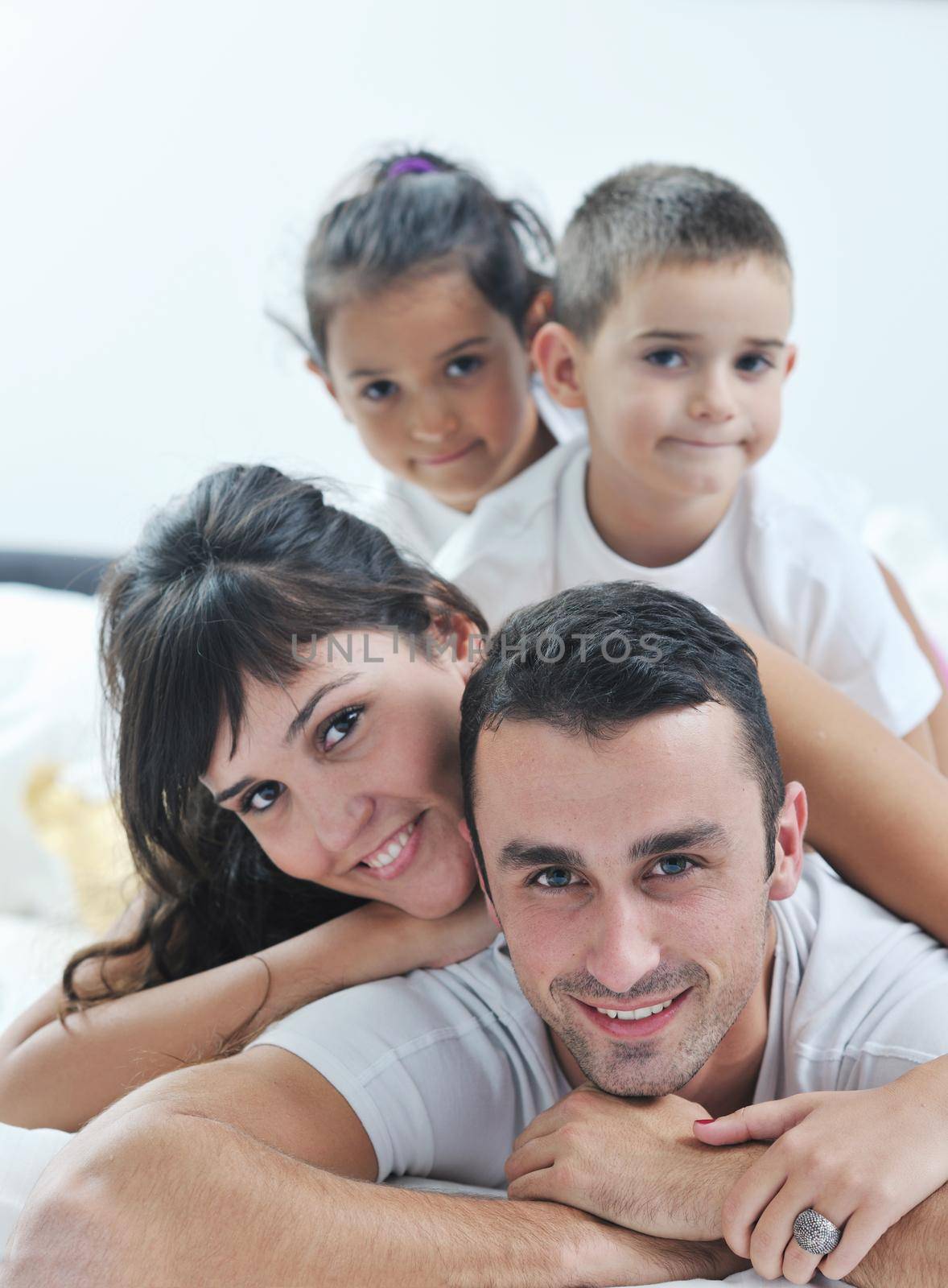 happy young Family in their bedroom have fun and play in bed