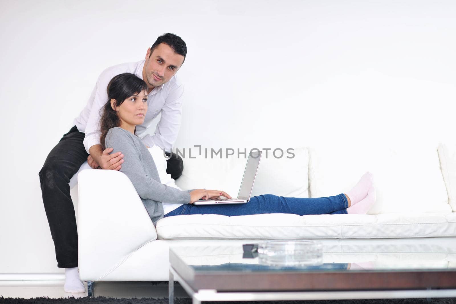 joyful couple relax and work on laptop computer at modern living room indoor home