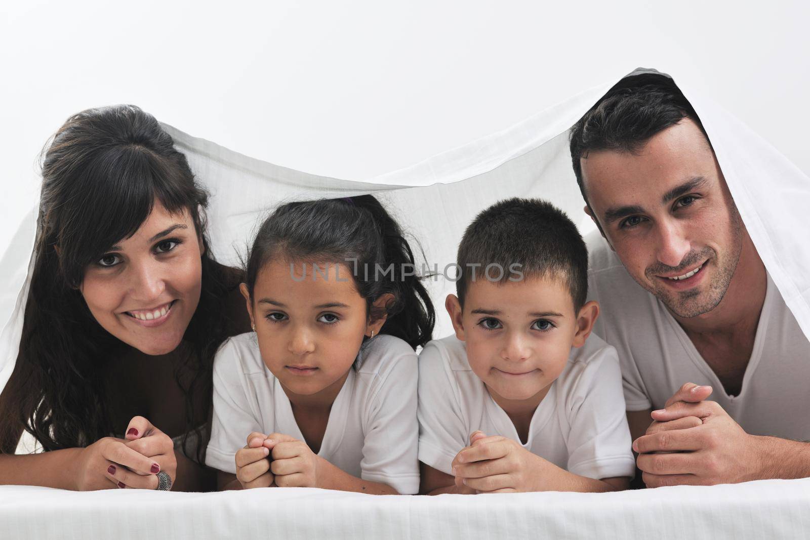 happy young Family in their bedroom have fun and play in bed