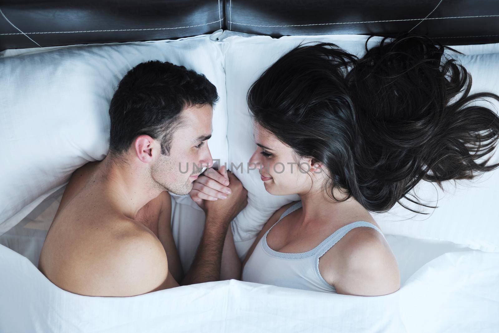 happy young healthy people  couple have good time in their bedroom make love and sleep