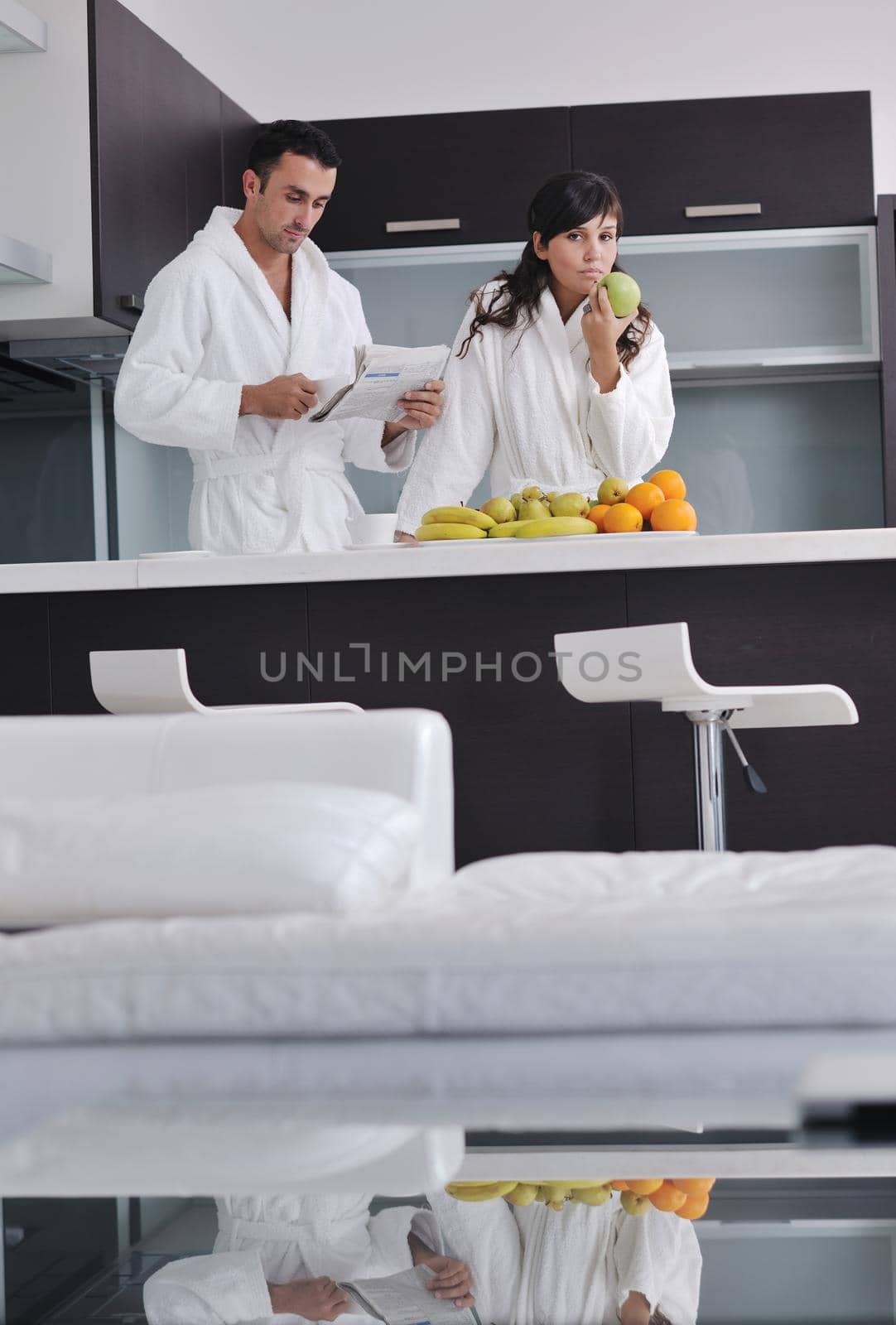 young family couple read newspaper at kitchen in morning with  fresh breakfast  fruits food and coffee drink on table