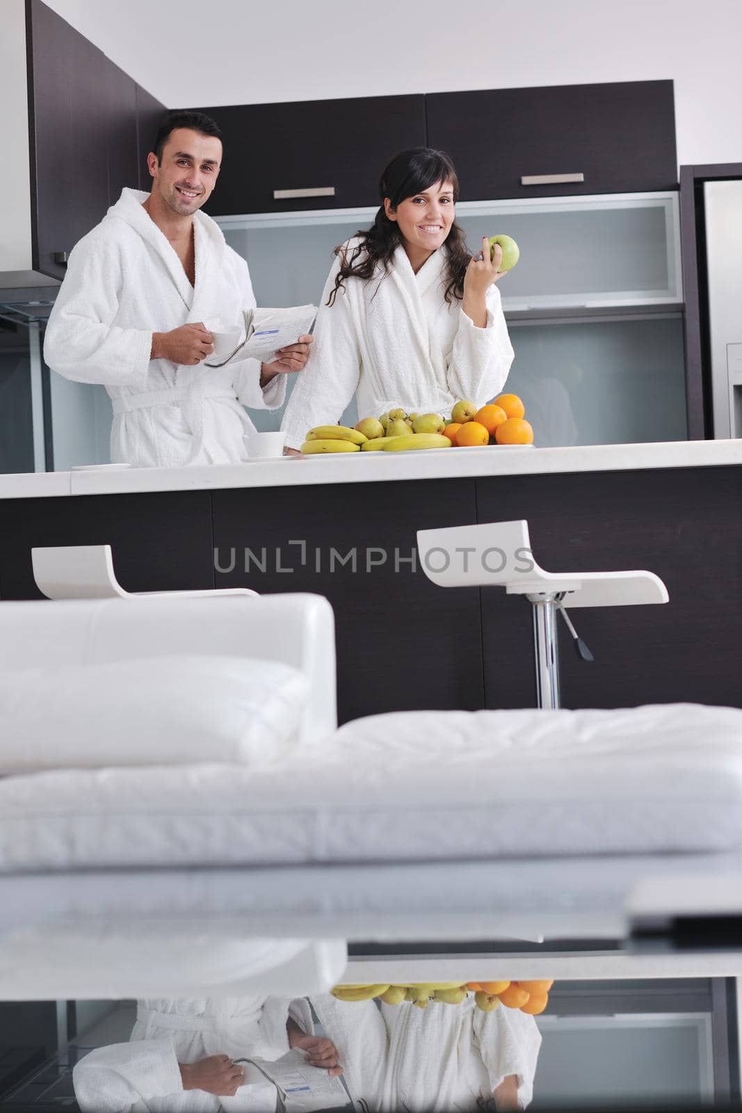 happy young couple have fun in  modern kitchen indoor  while preparing fresh fruits and vegetables food salad