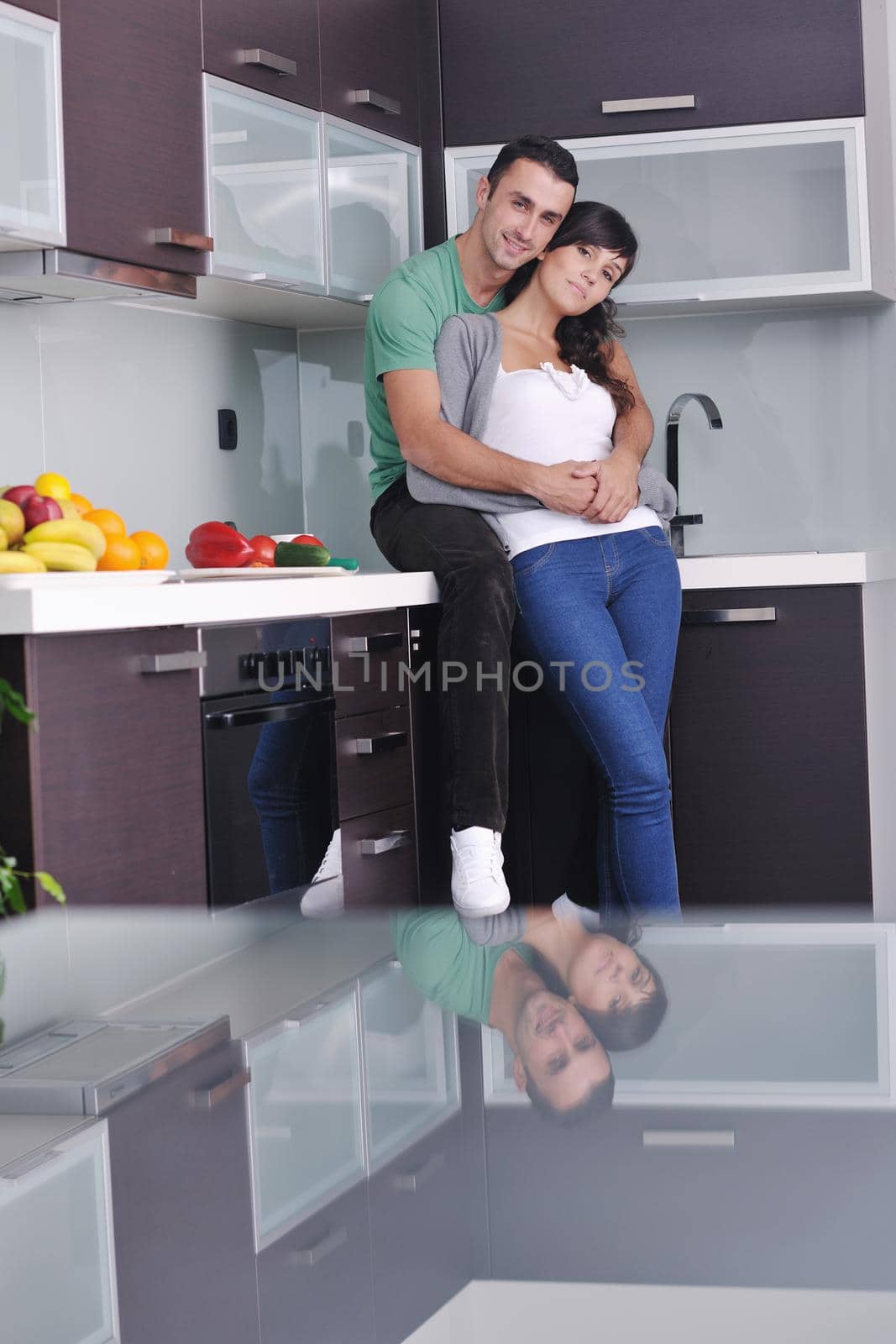 happy young couple have fun in  modern kitchen indoor  while preparing fresh fruits and vegetables food salad