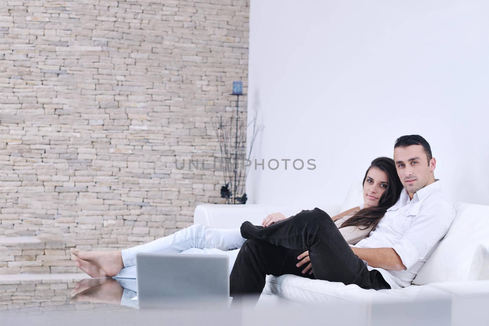 Relaxed young  couple watching tv at home by dotshock
