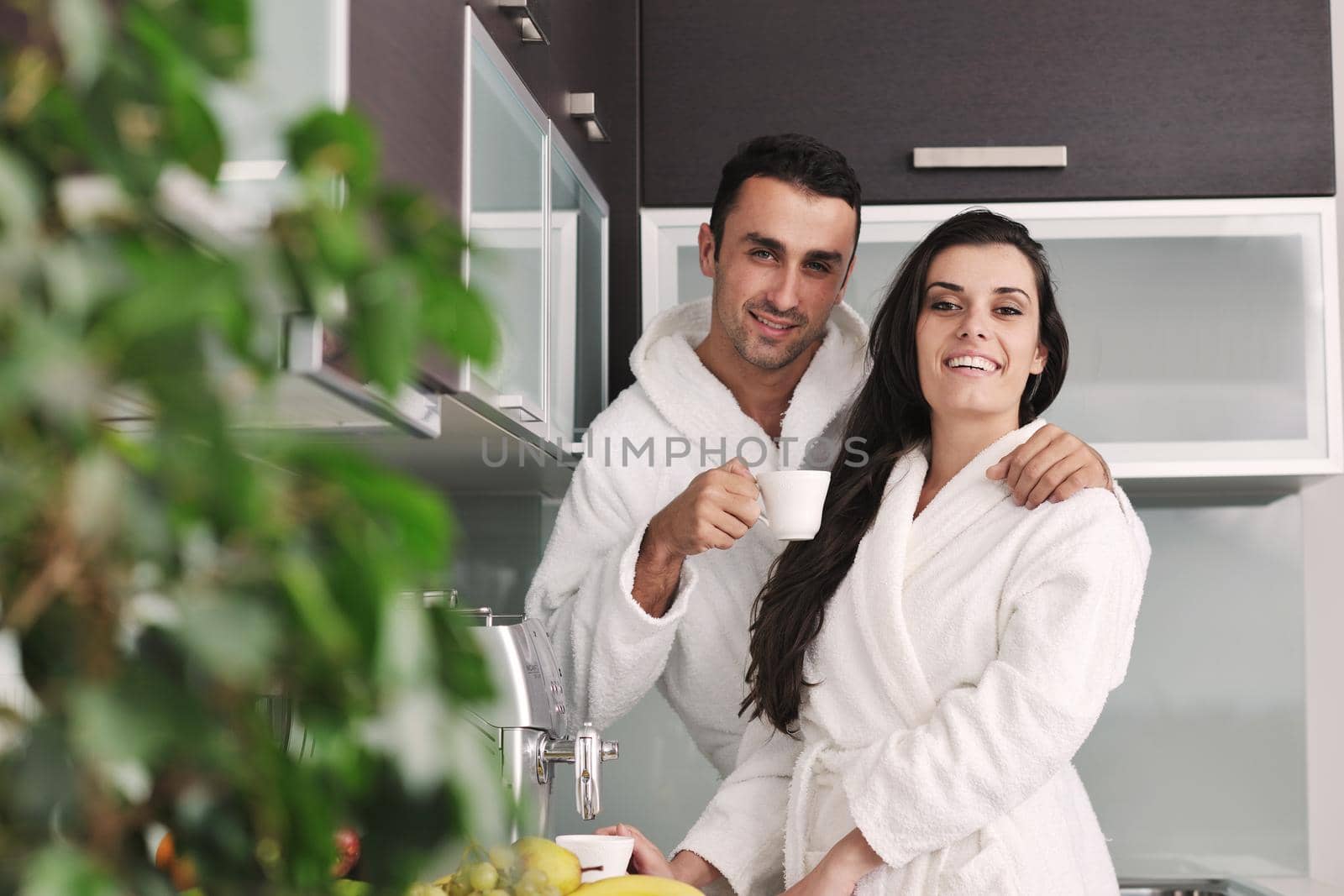 Young love couple taking fresh morning cup of coffee in the modern appartment