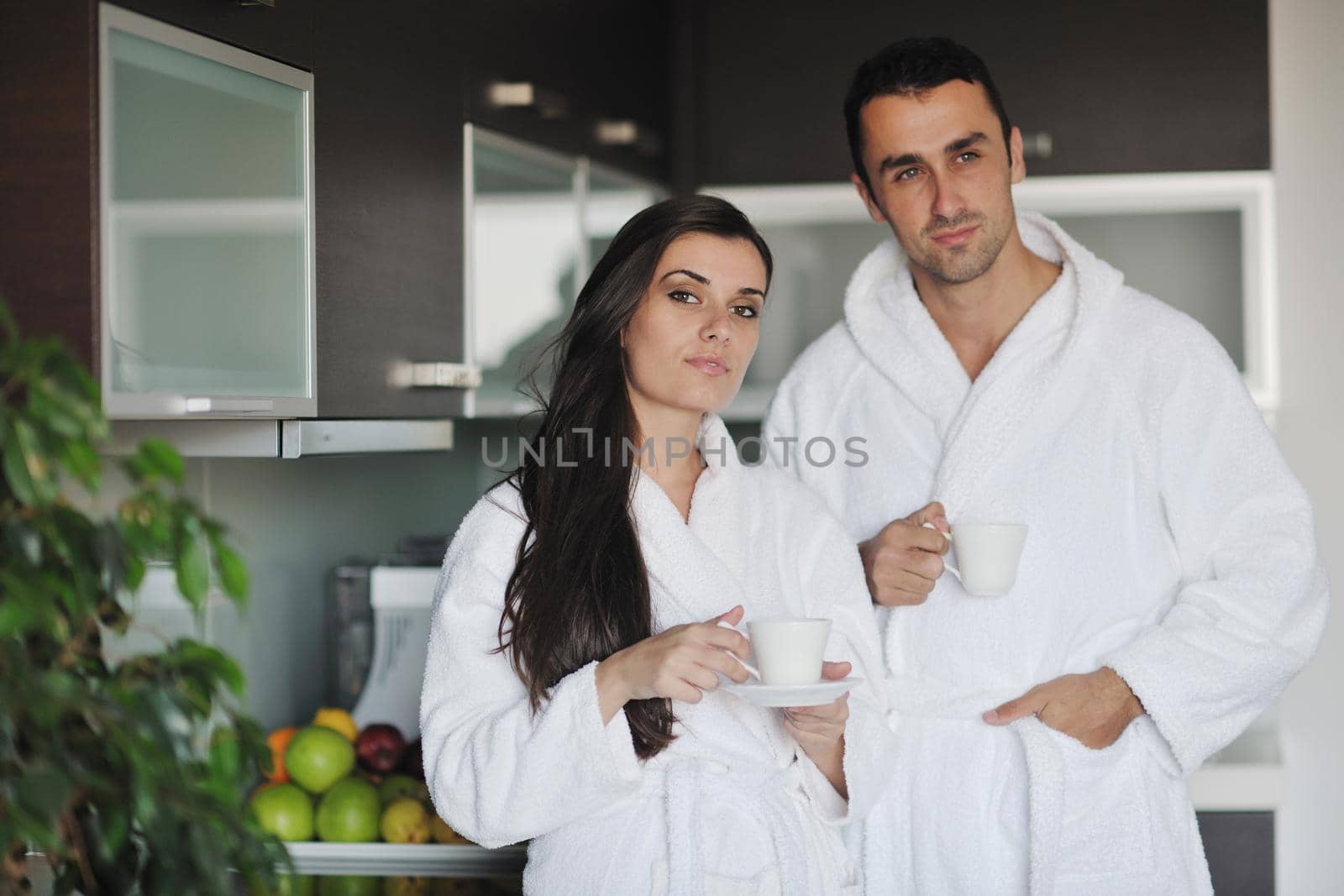 Young love couple taking fresh morning cup of coffee in the modern appartment