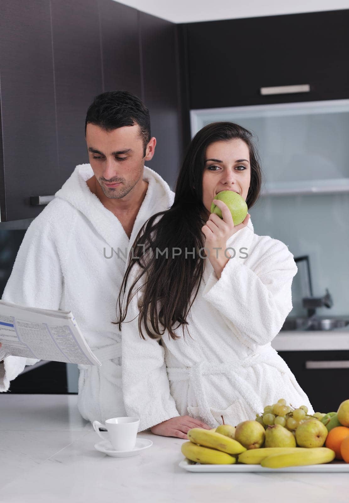 happy young couple have fun in  modern kitchen indoor  while preparing fresh fruits and vegetables food salad